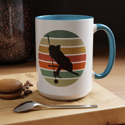 Mug with red accents and a graphic of a billiards player silhouette over a colorful retro design on cutting board with coffee beans, a spoon, and a cookie.