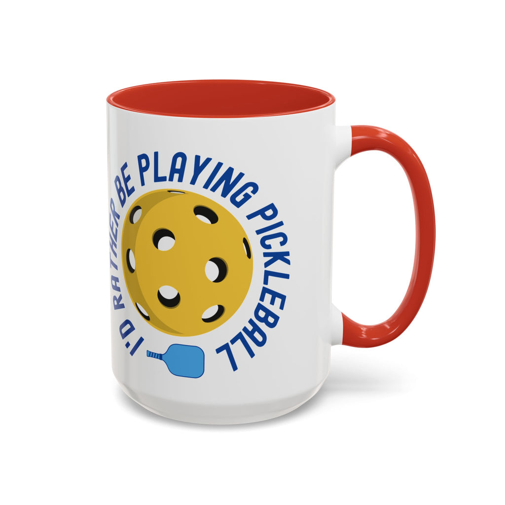 Coffee mug with red accents on the handle and inside, with a yellow pickleball and blue pickleball paddle with the words "I'd Rather Be Playing Pickleball" on a white background