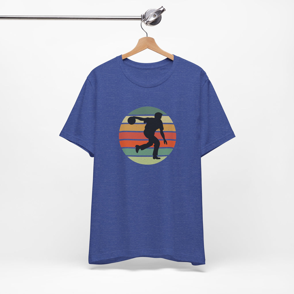 Blue t-shirt with a graphic of a silhouette of a bowler over a colorful retro image, hanging on a wooden hanger against a white background.