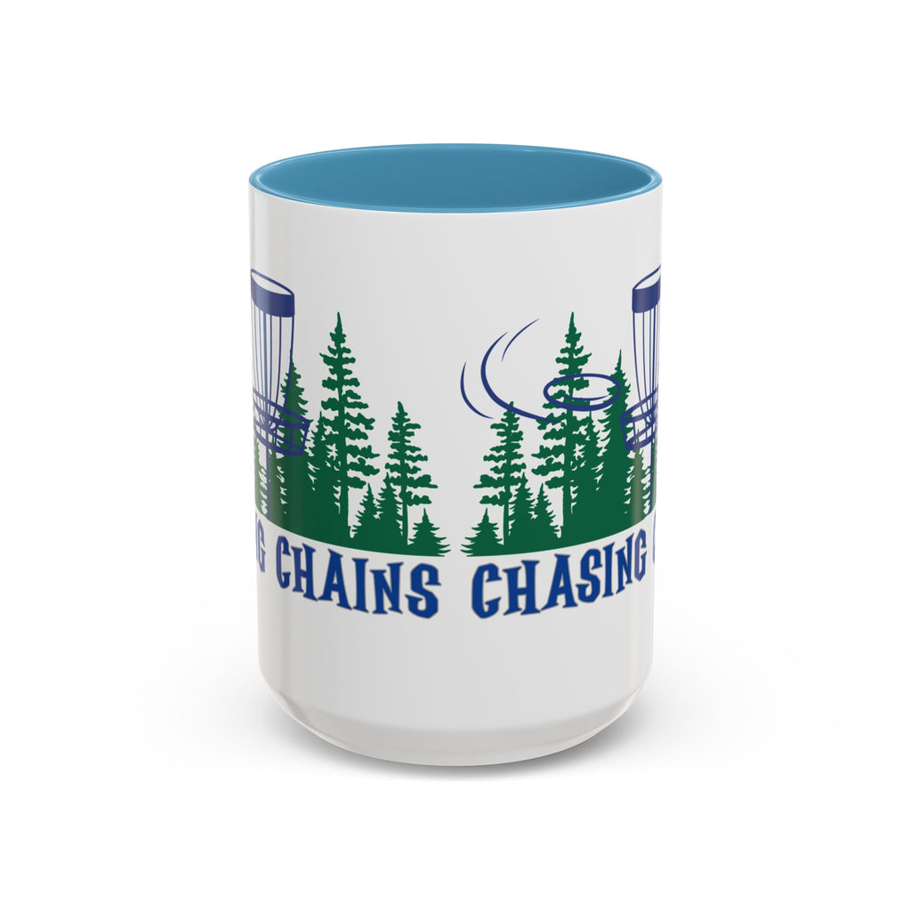 Front view of a ceramic coffee mug with blue accents on the handle and interior, with 'Chasing Chains' graphic featuring a flying disc golf disc and basket and chains in front of a scenic evergreen tree landscape, against a white background