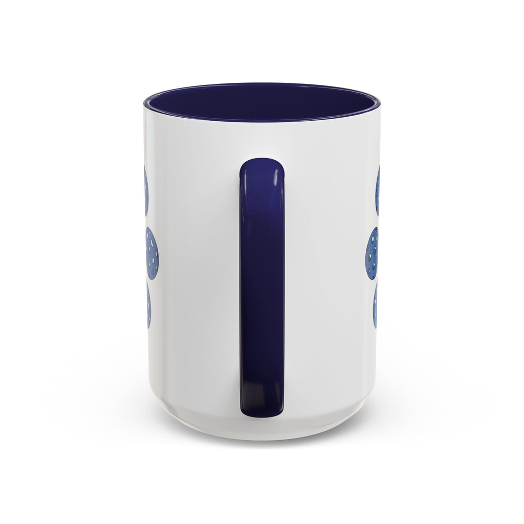 Back view of a ceramic coffee mug with dark blue accents on the handle and interior, with a colorful geometric design of pickleballs against a white background