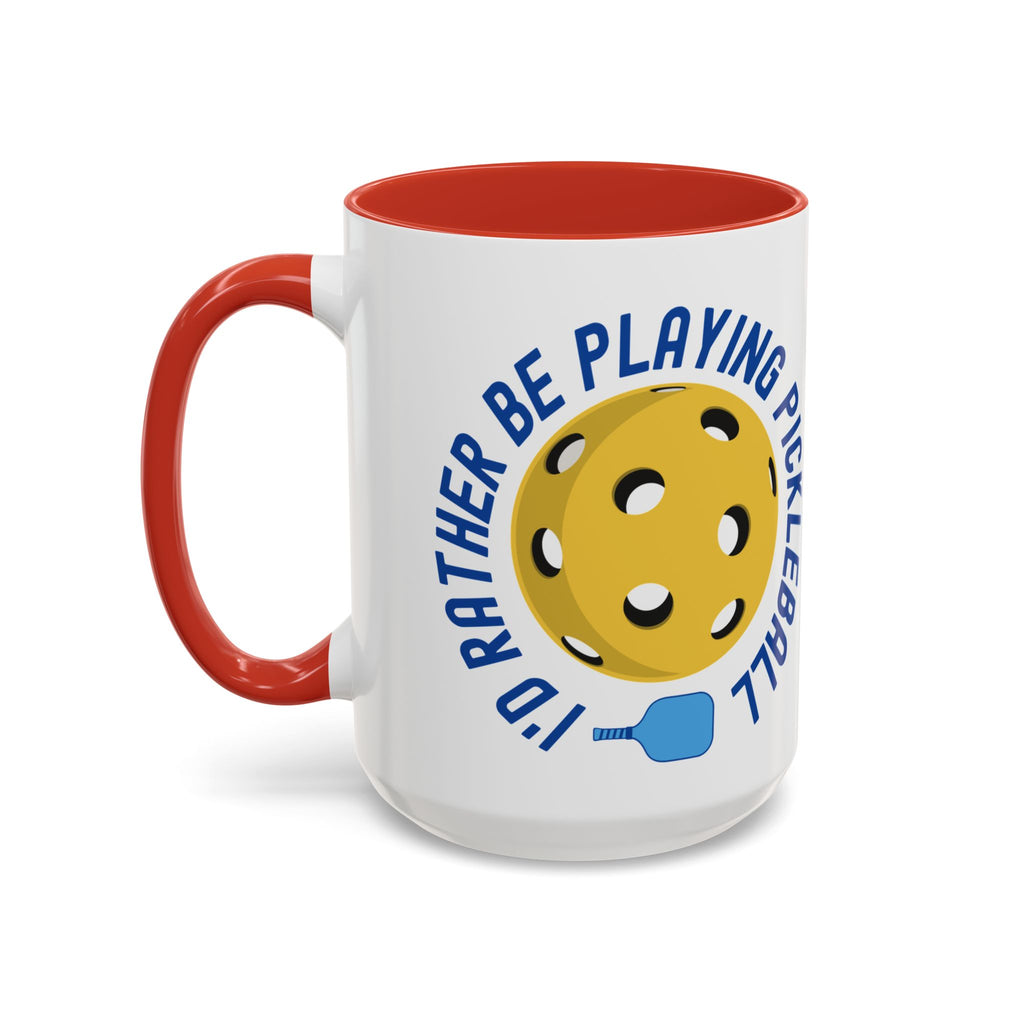 Coffee mug with red accents on the handle and inside, with a yellow pickleball and blue pickleball paddle with the words "I'd Rather Be Playing Pickleball" on a white background