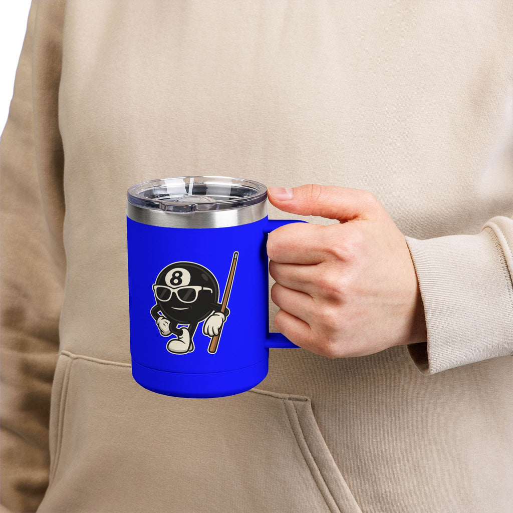 A person holding a blue travel coffee mug tumbler with handle and a lid, with a graphic of a cartoon billiards 8 ball with arms and legs and wearing sunglasses and leaning on a cue stick
