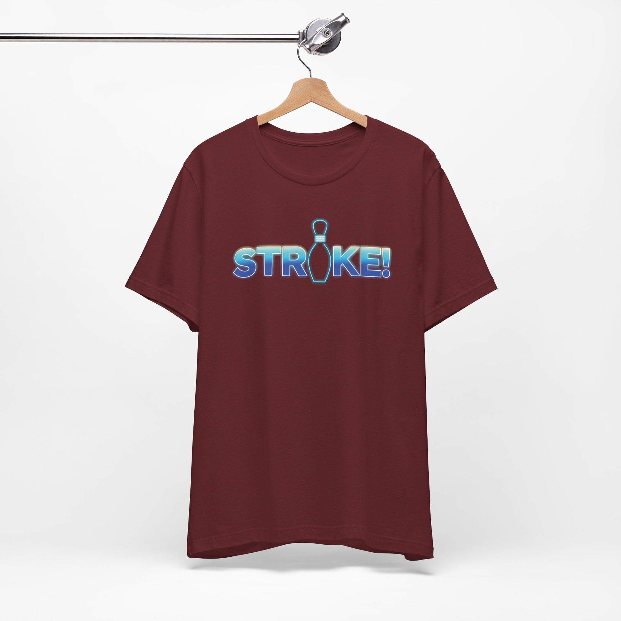 Maroon bowling t-shirt with 'STRIKE!' with the "I" replaced by a bowling pin, on a hanger against a white background