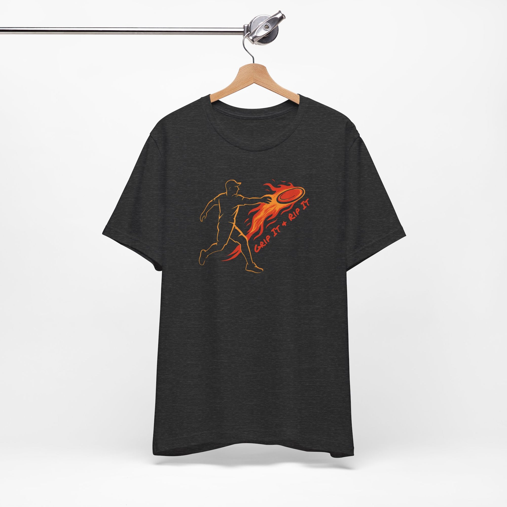 Dark gray t-shirt with a graphic design of a person throwing a disc golf disc with flames coming off the disc and text 'Grip It or Rip It' on a hanger against a white background.