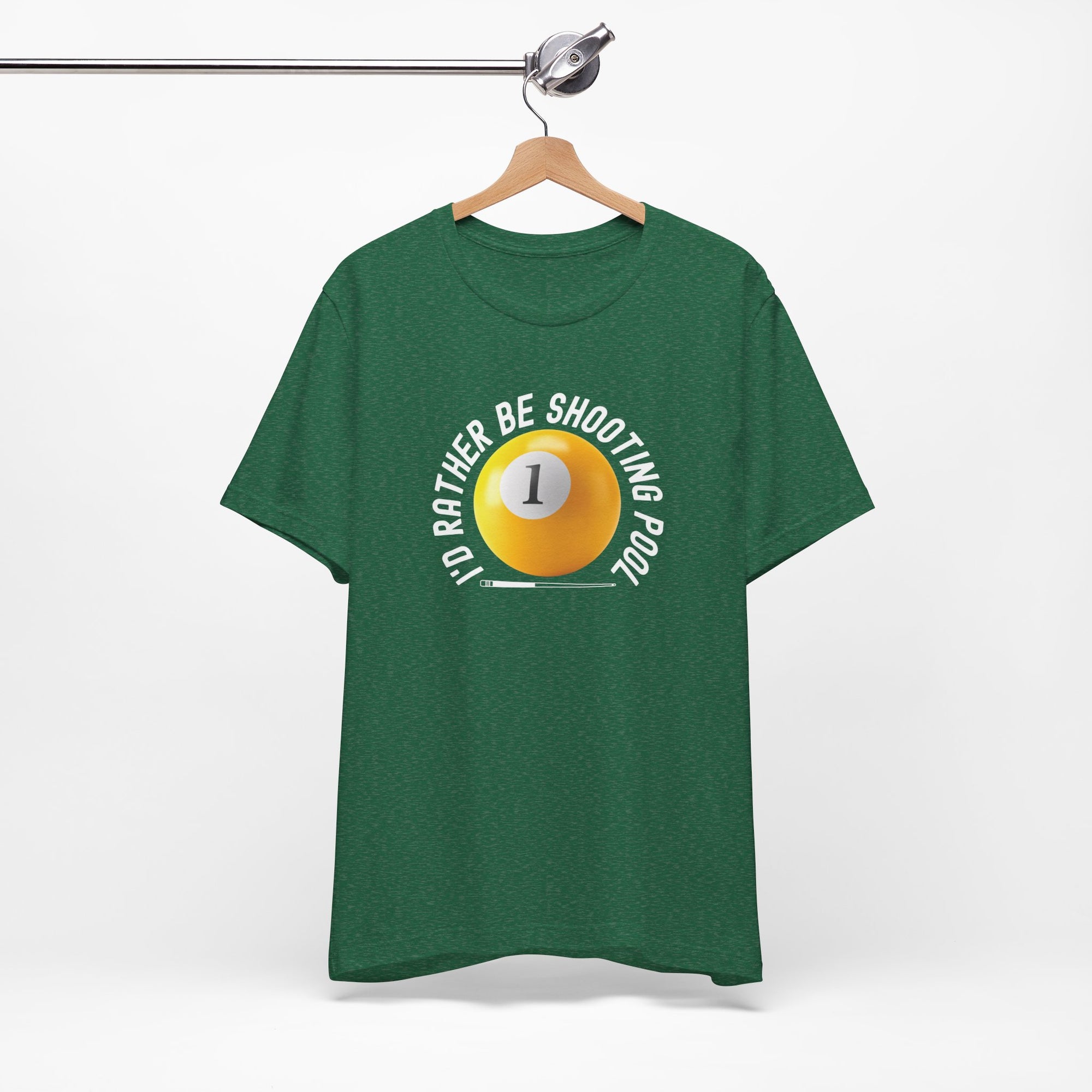 Green t-shirt with a yellow billiards ball and cue stick graphic and the text "I'd Rather Be Shooting Pool" on a hanger against a white background