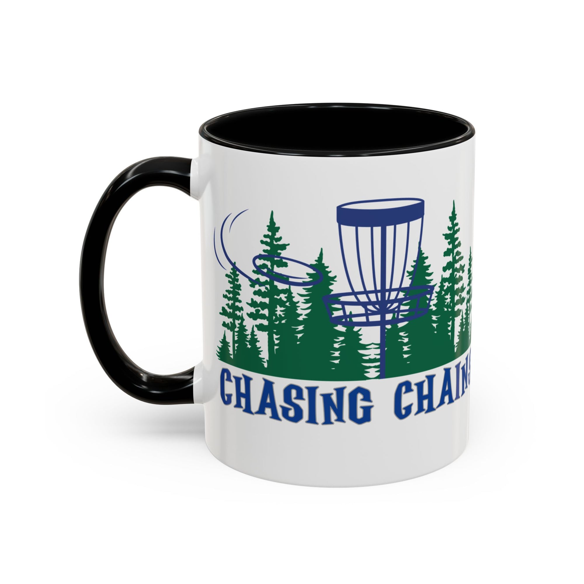 A ceramic coffee mug with black accents on the handle and interior, with 'Chasing Chains' graphic featuring a flying disc golf disc and basket and chains in front of a scenic evergreen tree landscape, against a white background