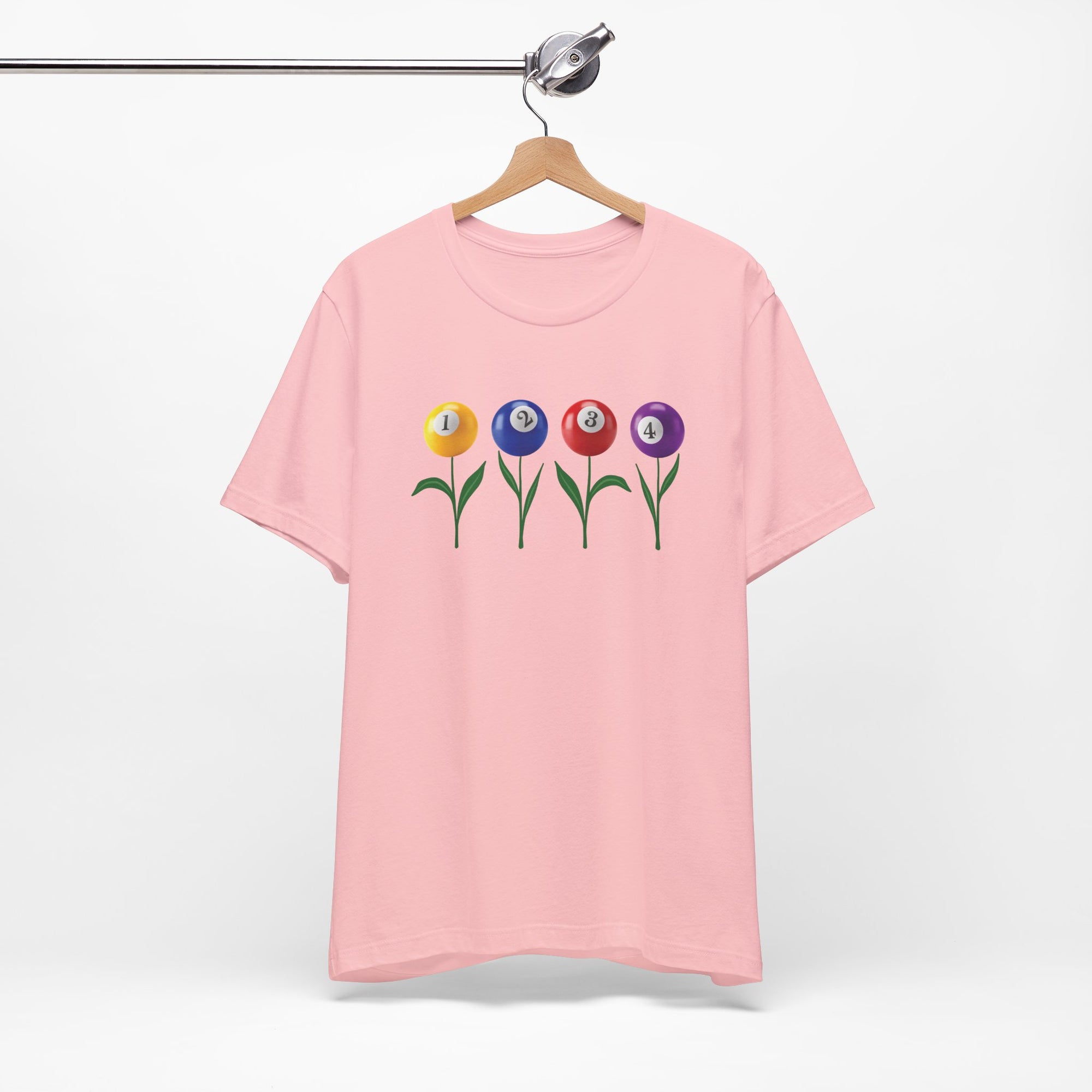 Pink t-shirt with four colorful flowers made out of billiards balls with green stems, on a hanger against a white background