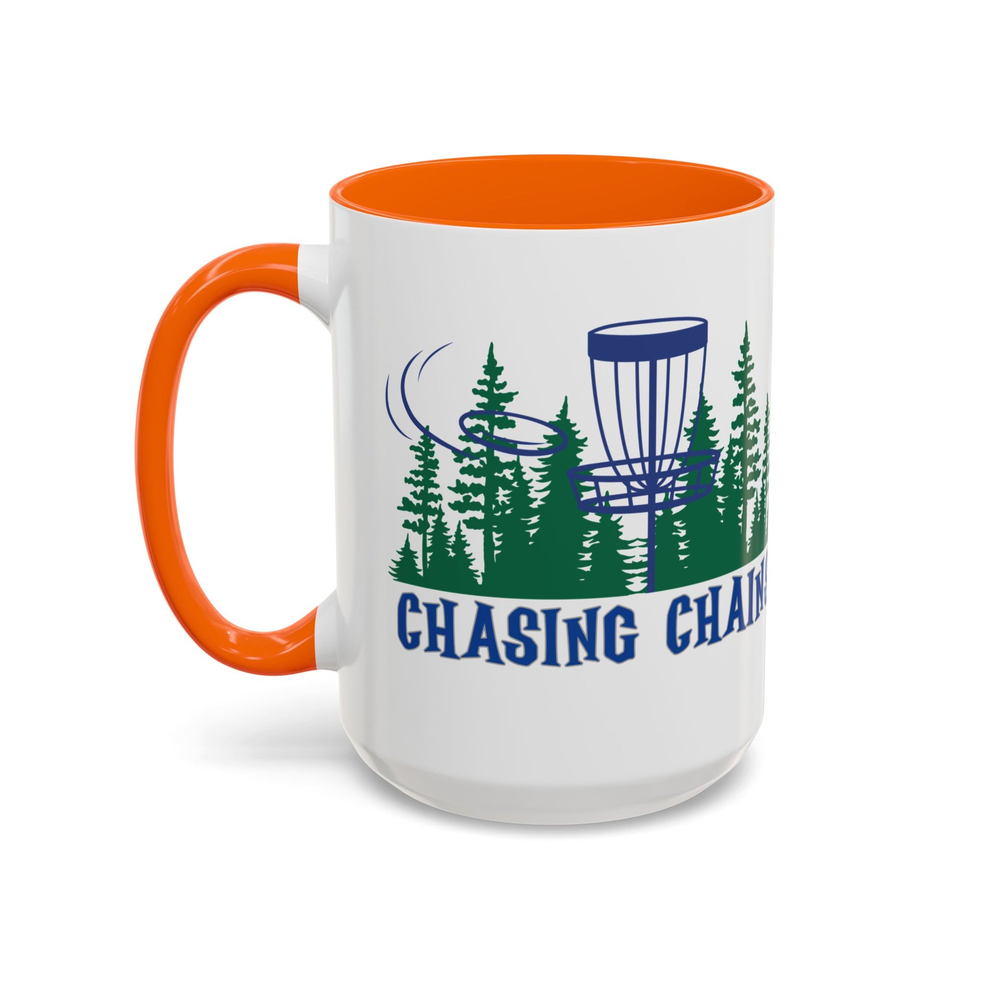 A ceramic coffee mug with orange accents on the handle and interior, with 'Chasing Chains' graphic featuring a flying disc golf disc and basket and chains in front of a scenic evergreen tree landscape, against a white background