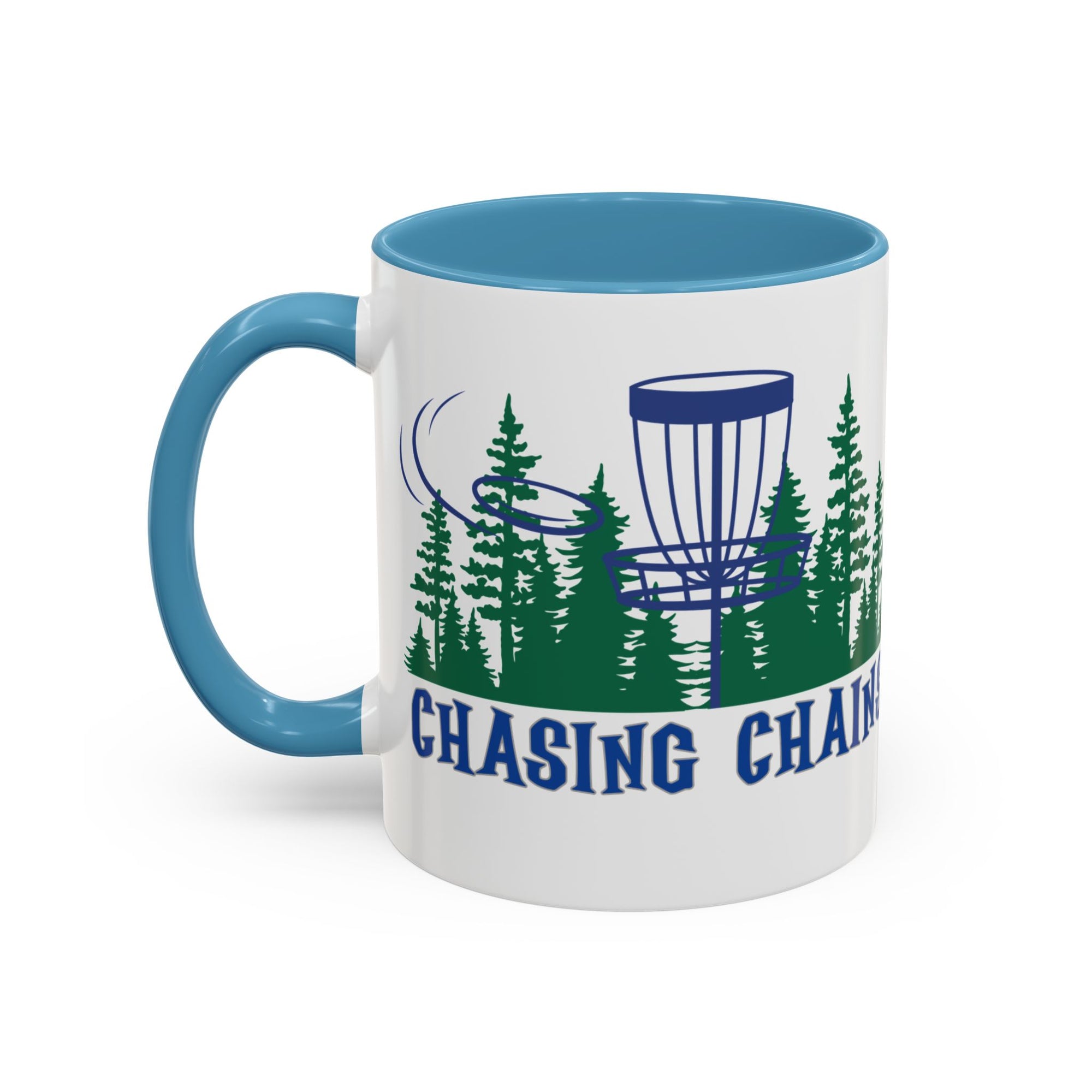 A ceramic coffee mug with light blue accents on the handle and interior, with 'Chasing Chains' graphic featuring a flying disc golf disc and basket and chains in front of a scenic evergreen tree landscape, against a white background