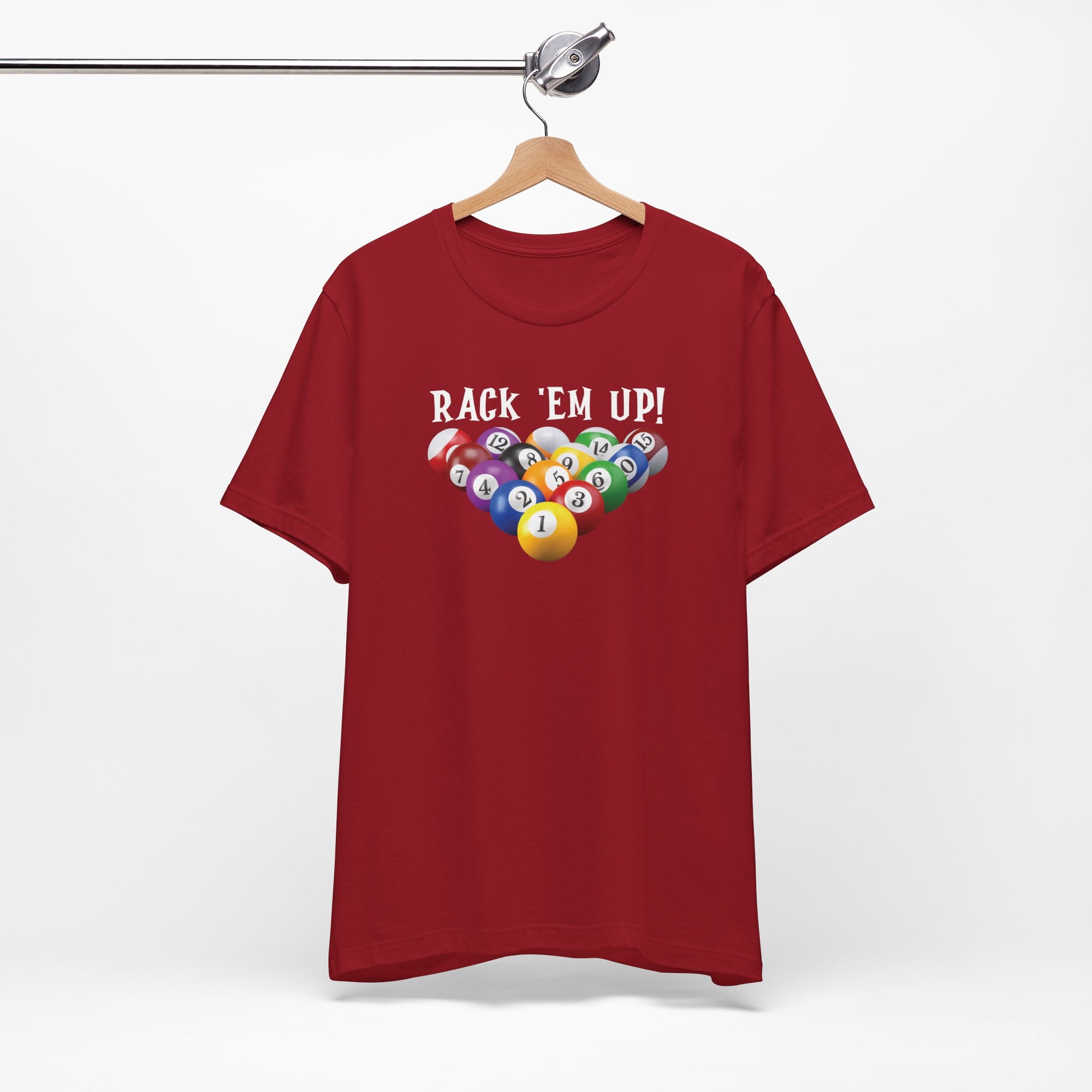 Maroon t-shirt with racked pool ball design and 'Rack 'Em Up!' text, on a hanger against a white background