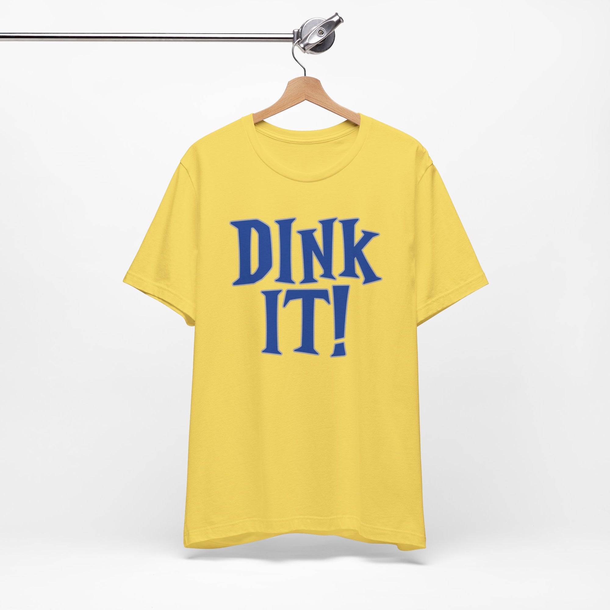 Yellow t-shirt with 'DINK IT!' text in blue and outlined in gray, on a hanger against a white background