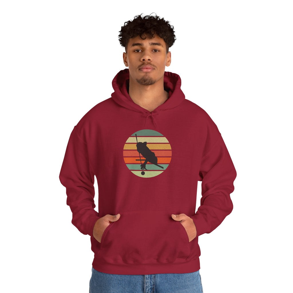 Person wearing a red hoodie with a graphic of a billiards player silhouette over a retro colorful image against a white background.
