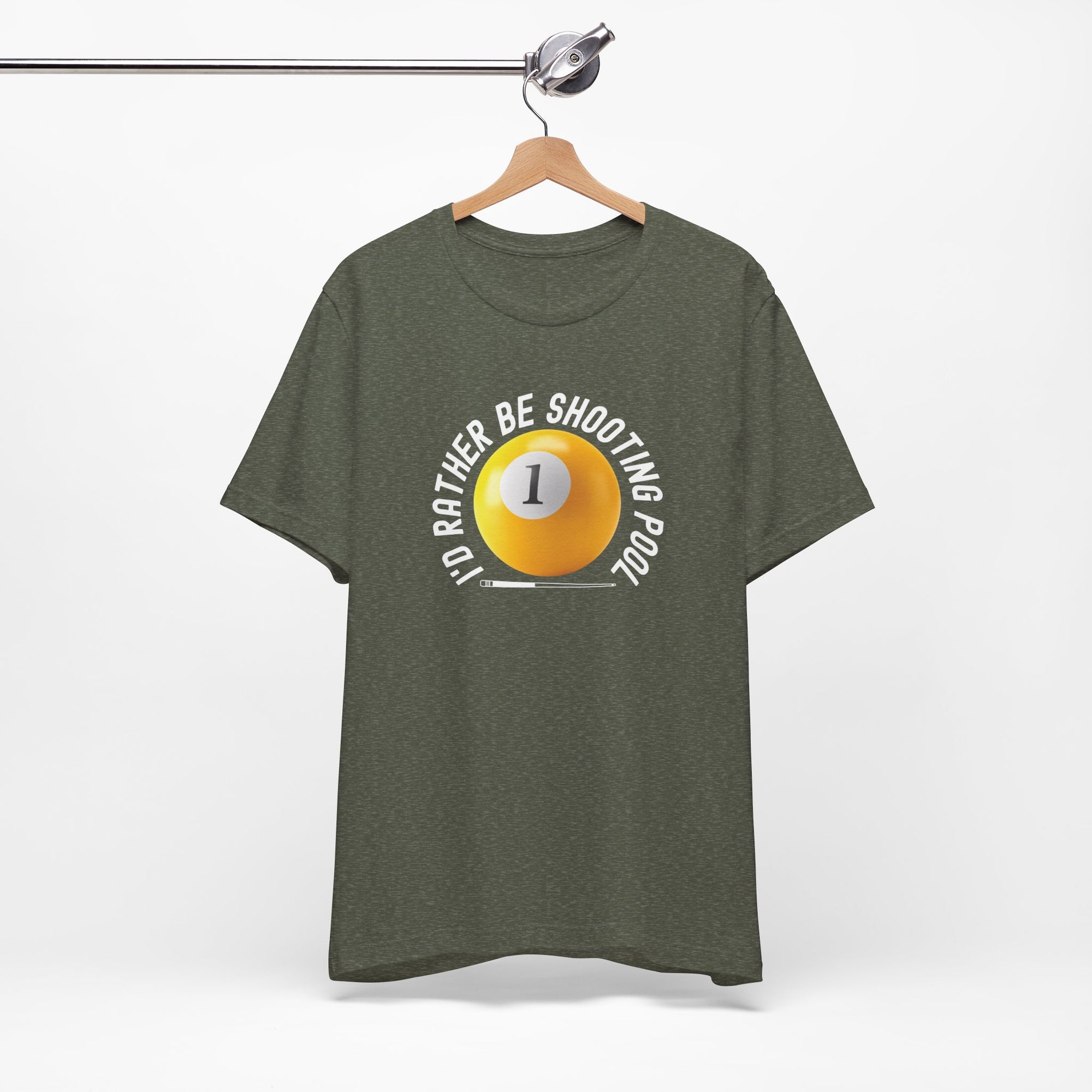Olive color t-shirt with a yellow billiards ball and cue stick graphic and the text "I'd Rather Be Shooting Pool" on a hanger against a white background