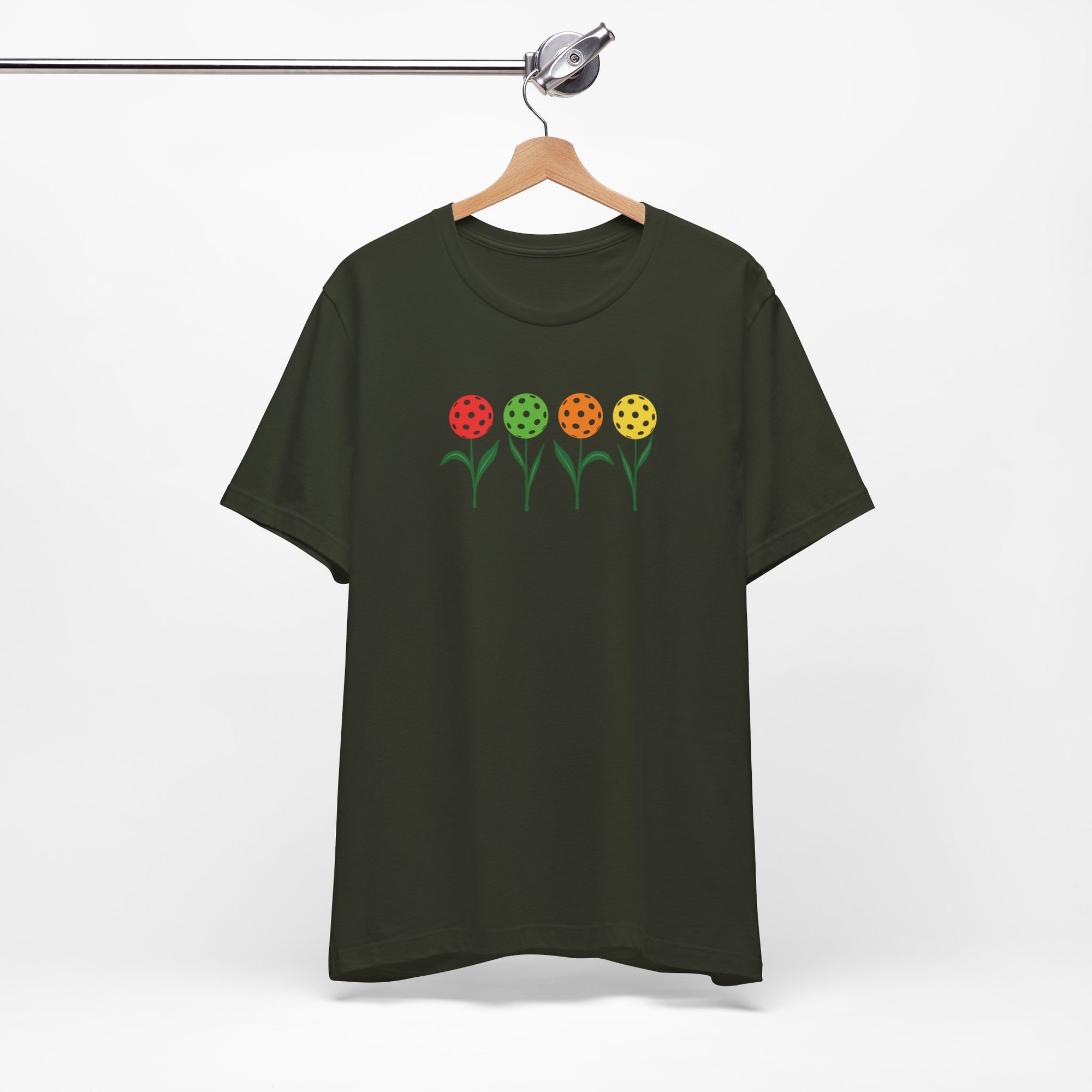 Gray t-shirt with colorful flowers made from pickleballs on green stems with leaves, on a hanger against a white background