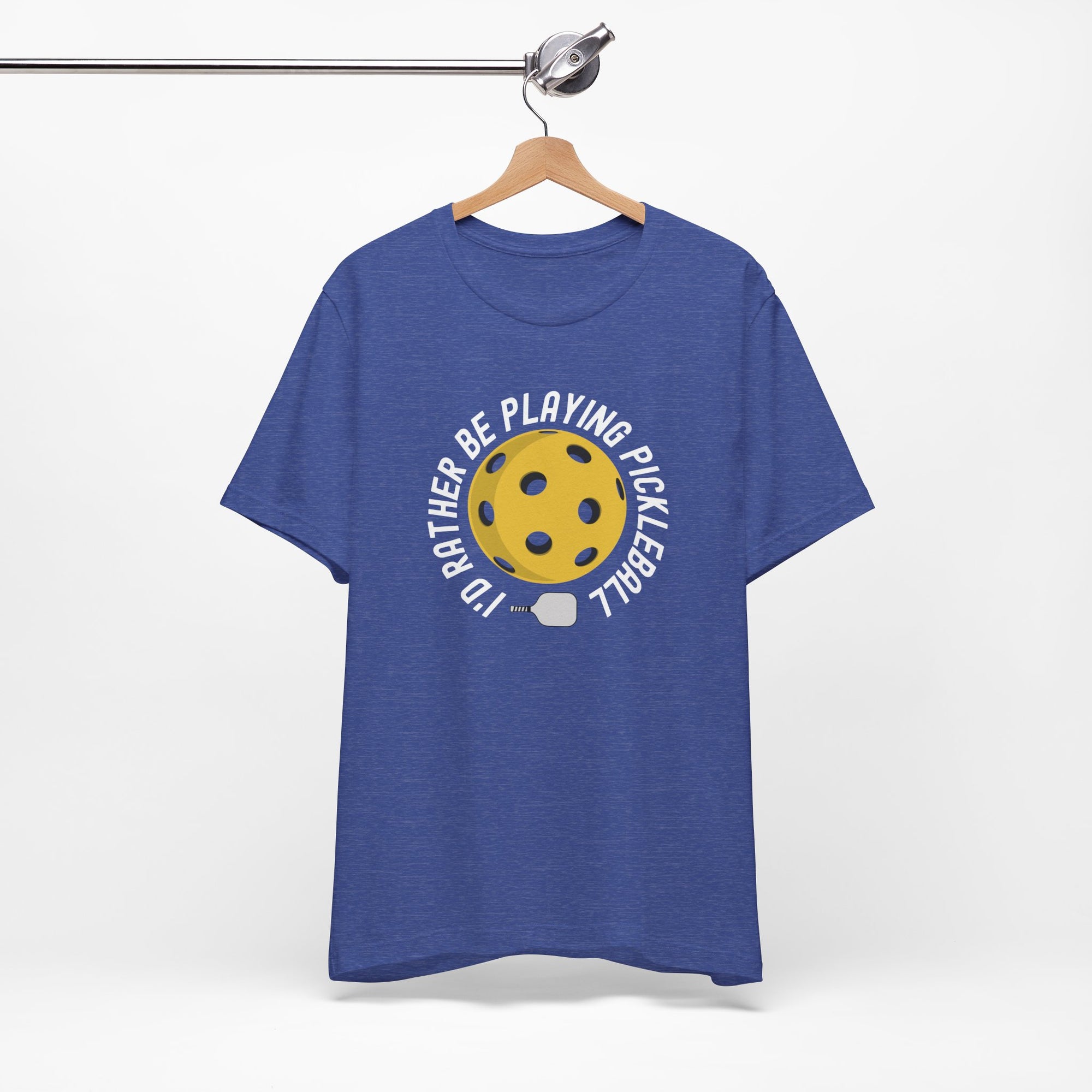 Blue t-shirt with a yellow pickleball and white pickleball paddle and the text "I'd Rather Be Playing Pickleball" on a hanger against a white background