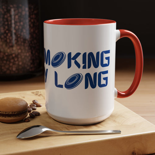 A ceramic coffee mug with red accents on the handle and interior, with 'CHAIN SMOKING ALL DAY LONG' text with the O's replaced by disc golf discs, in a coffee shop setting