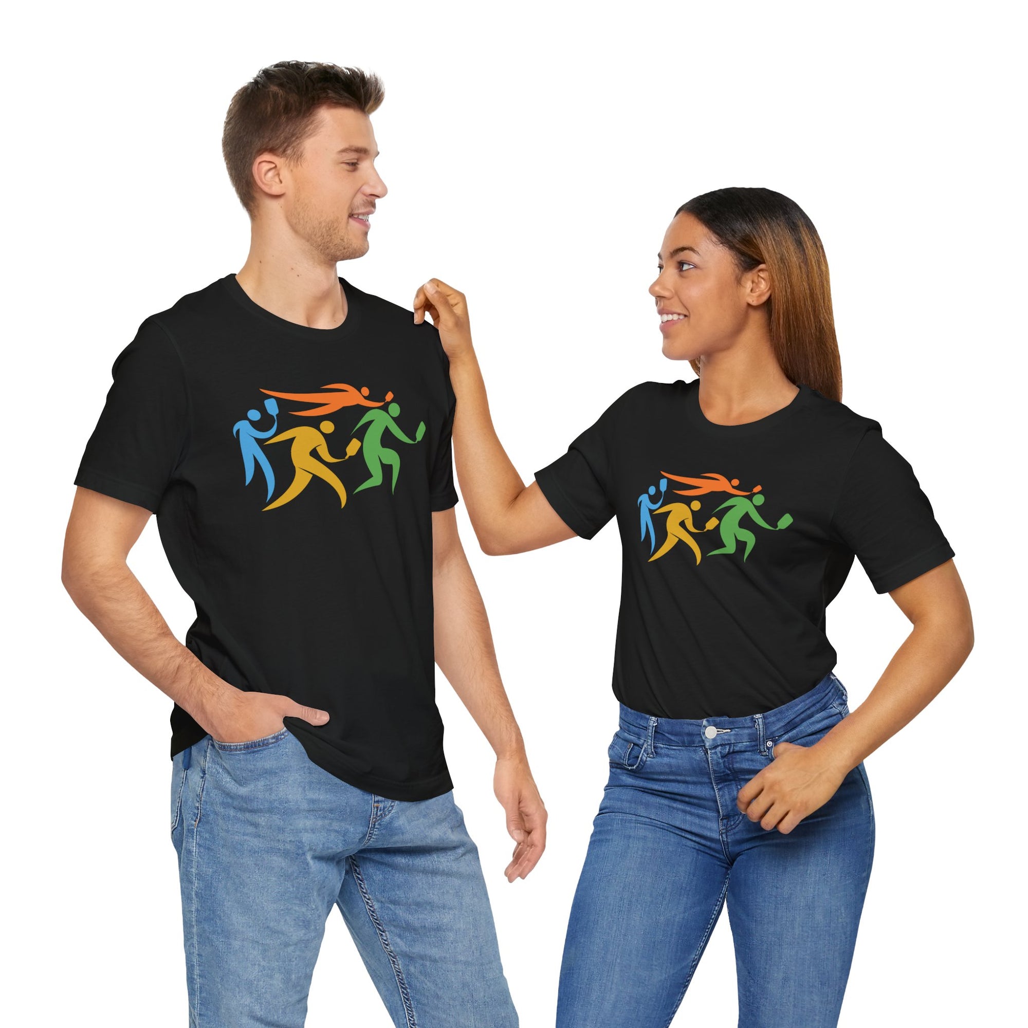 A man and a woman each wearing a black t-shirt featuring an image of four colorful pickleball player drawings playing pickleball, on a hanger against a white background