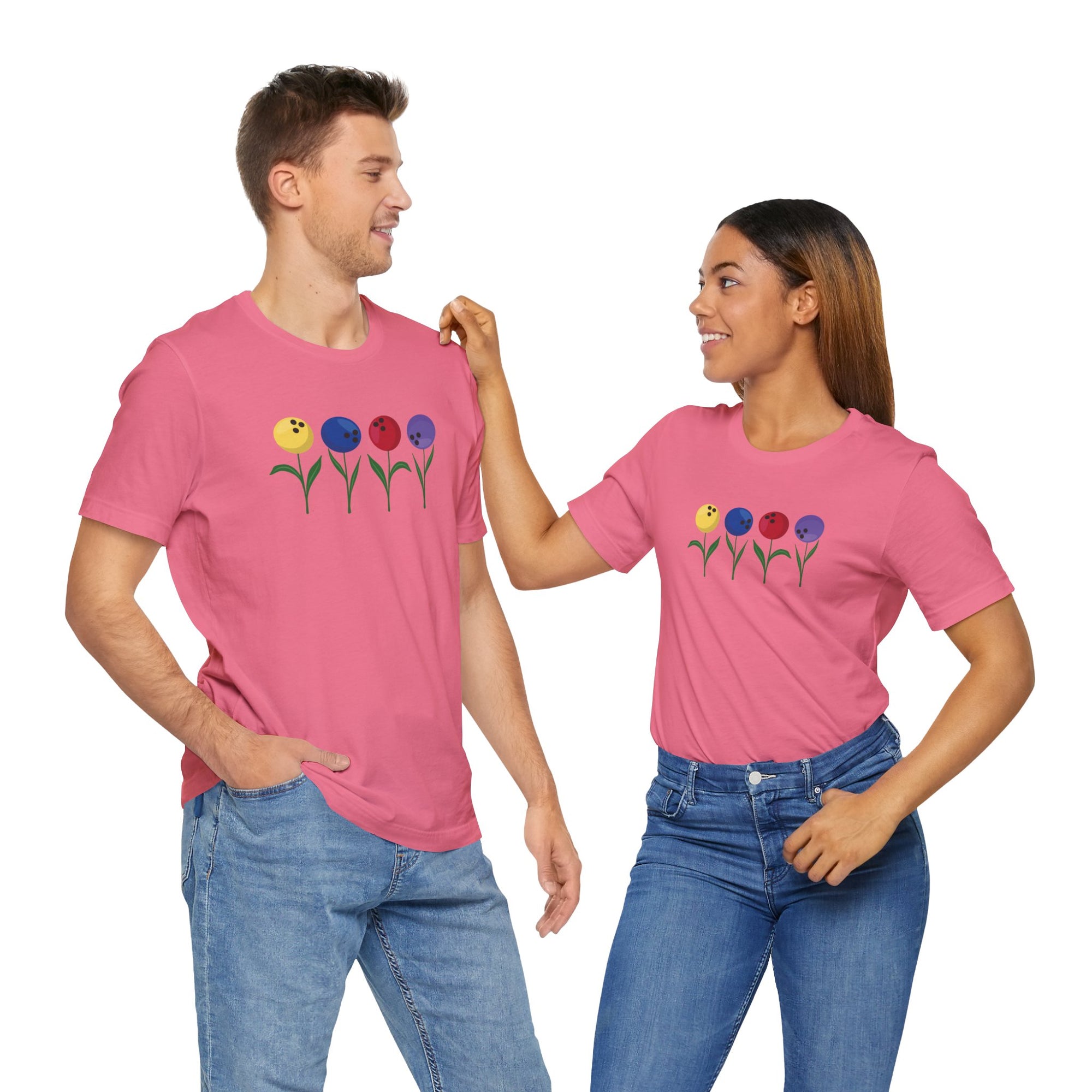 A man and a woman both wearing a pink t-shirt with colorful flowers made out of bowling balls, on a white background