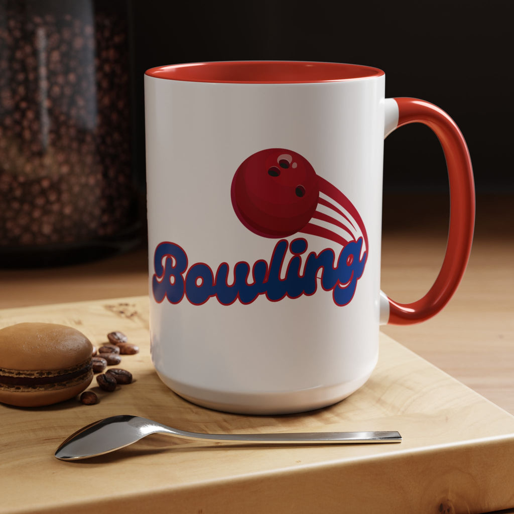 A white ceramic coffee mug with red accents on the handle and interior, with a red bowling ball graphic and 'Bowling' text in a coffee shop setting