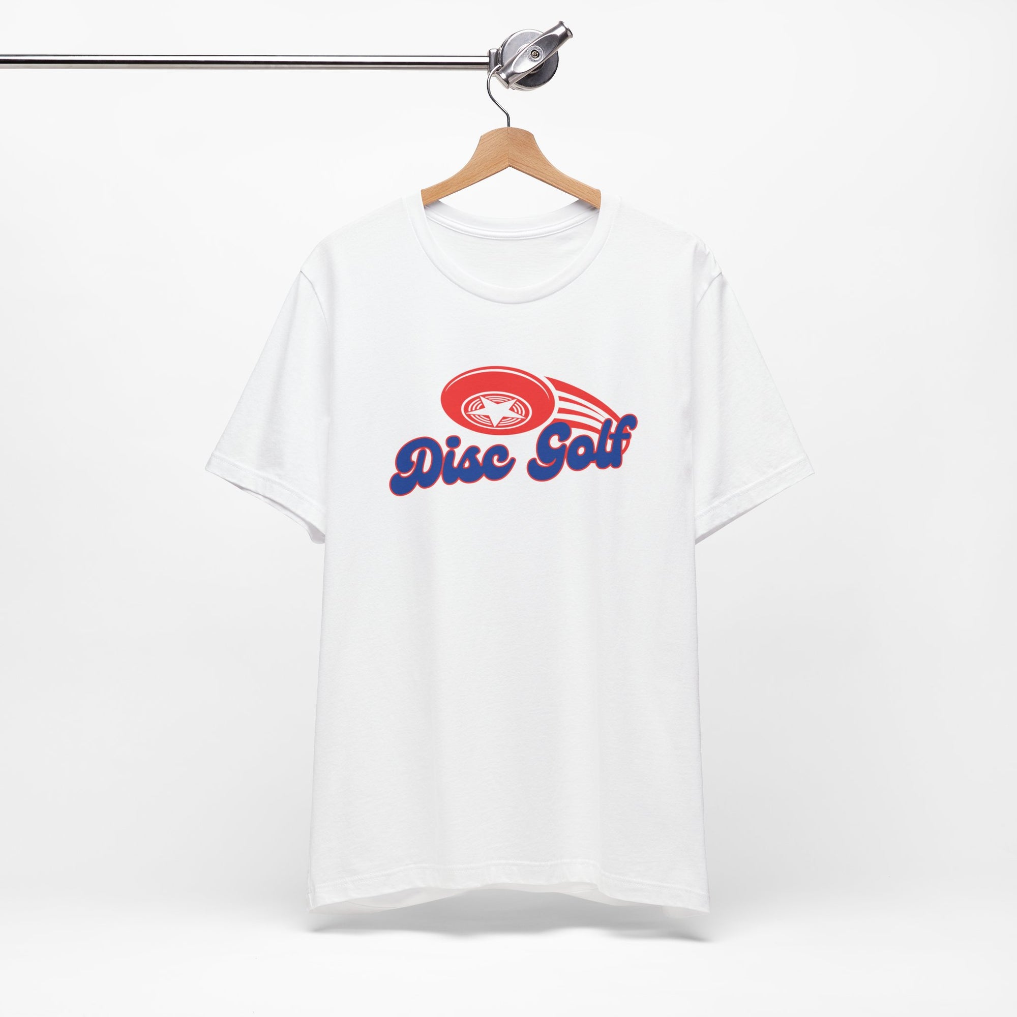 White t-shirt with 'Disc Golf' in a blue script text outlined in red and disc golf with motion trails, on a hanger against a white background
