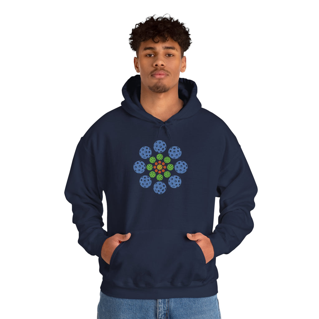 Man wearing a navy blue hoodie with colorful geometric design of pickleballs against a white background