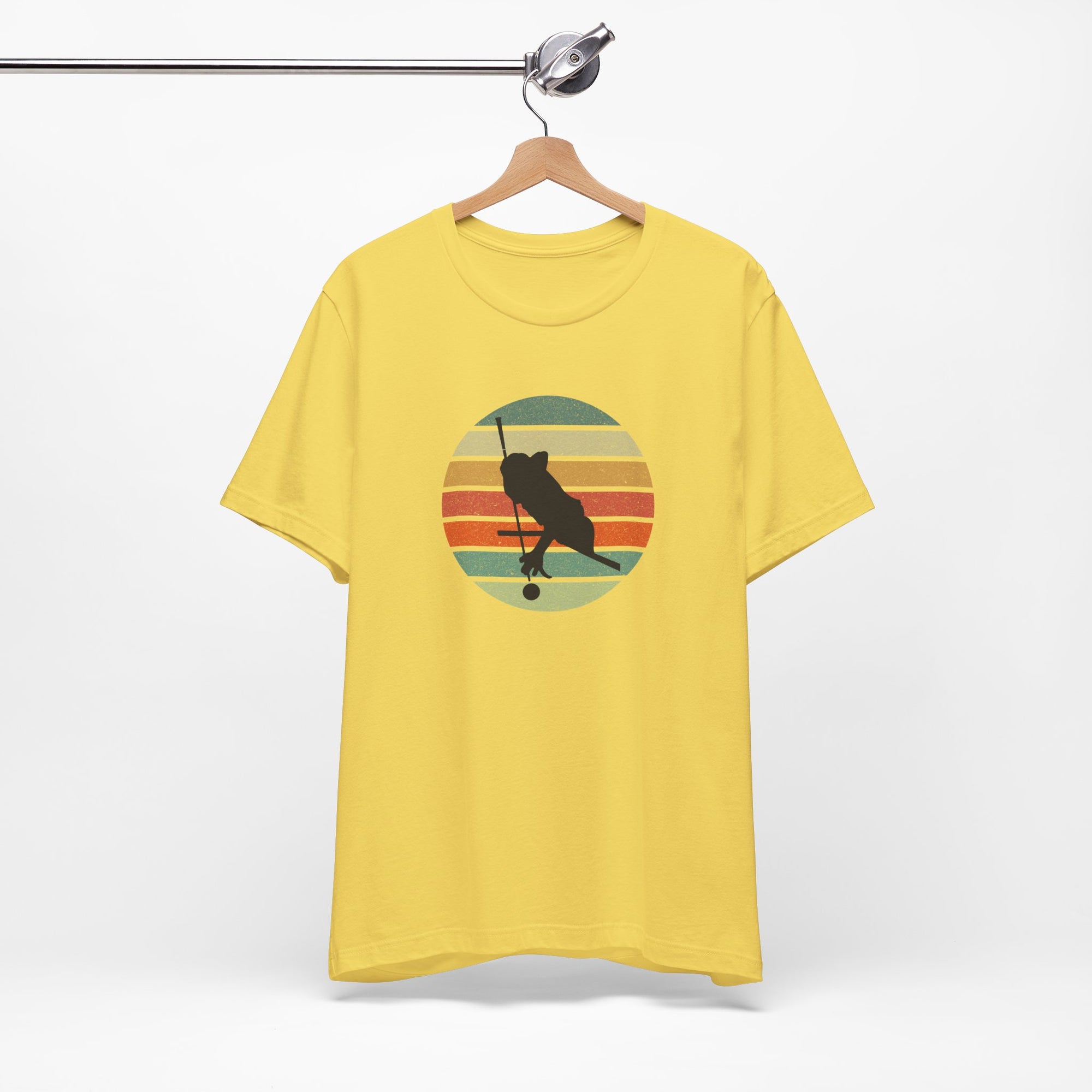 Yellow t-shirt with a graphic of a billiards player silhouette over a colorful retro image against a white background