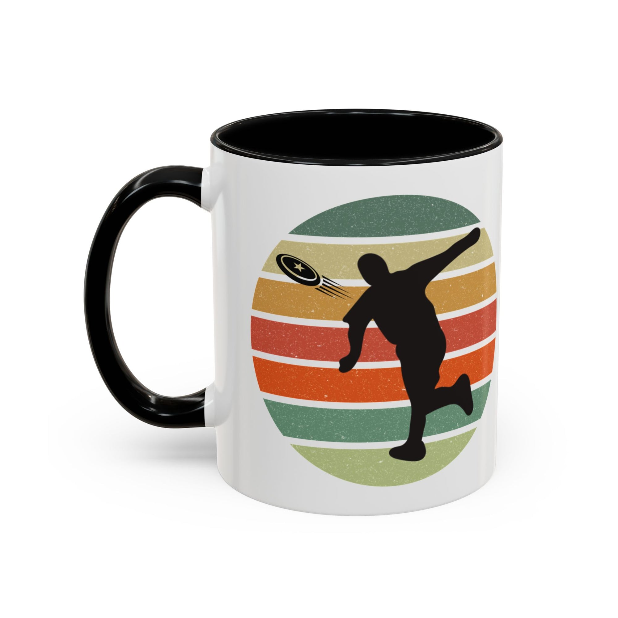 White ceramic coffee mug with black accents on the handle and inside. The mug features a graphic of a silhouette of a disc golf player above a colorful retro design.