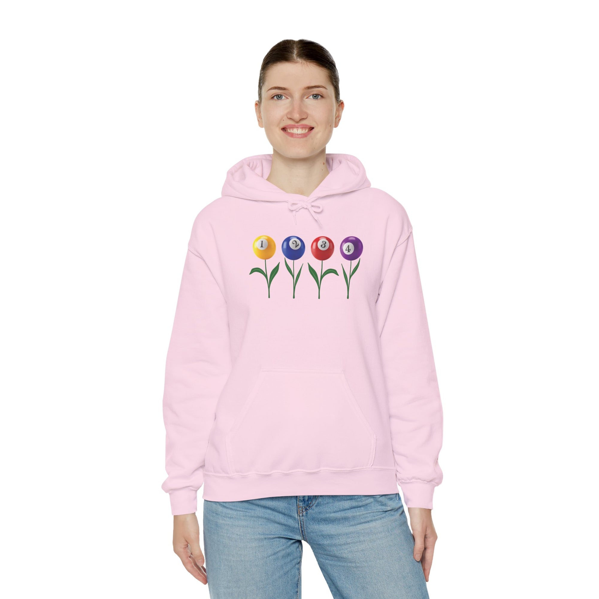 A woman wearing a pink hoodie with four colorful flowers made out of billiards balls with green stems, a white background