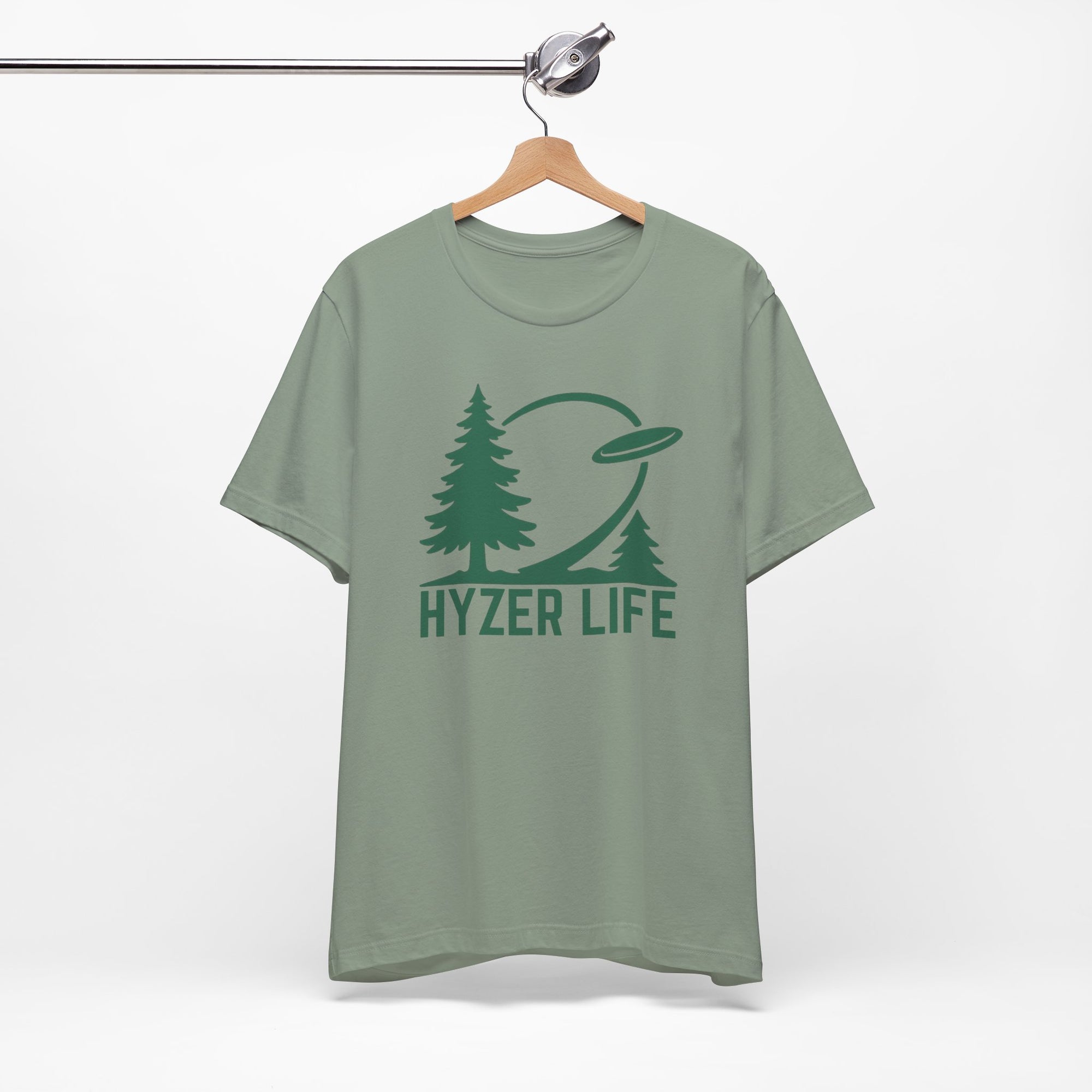 Teal t-shirt with green graphic of trees and a disc golf flying with the words 'HYZER LIFE' below the image, on a hanger against a white backgroud