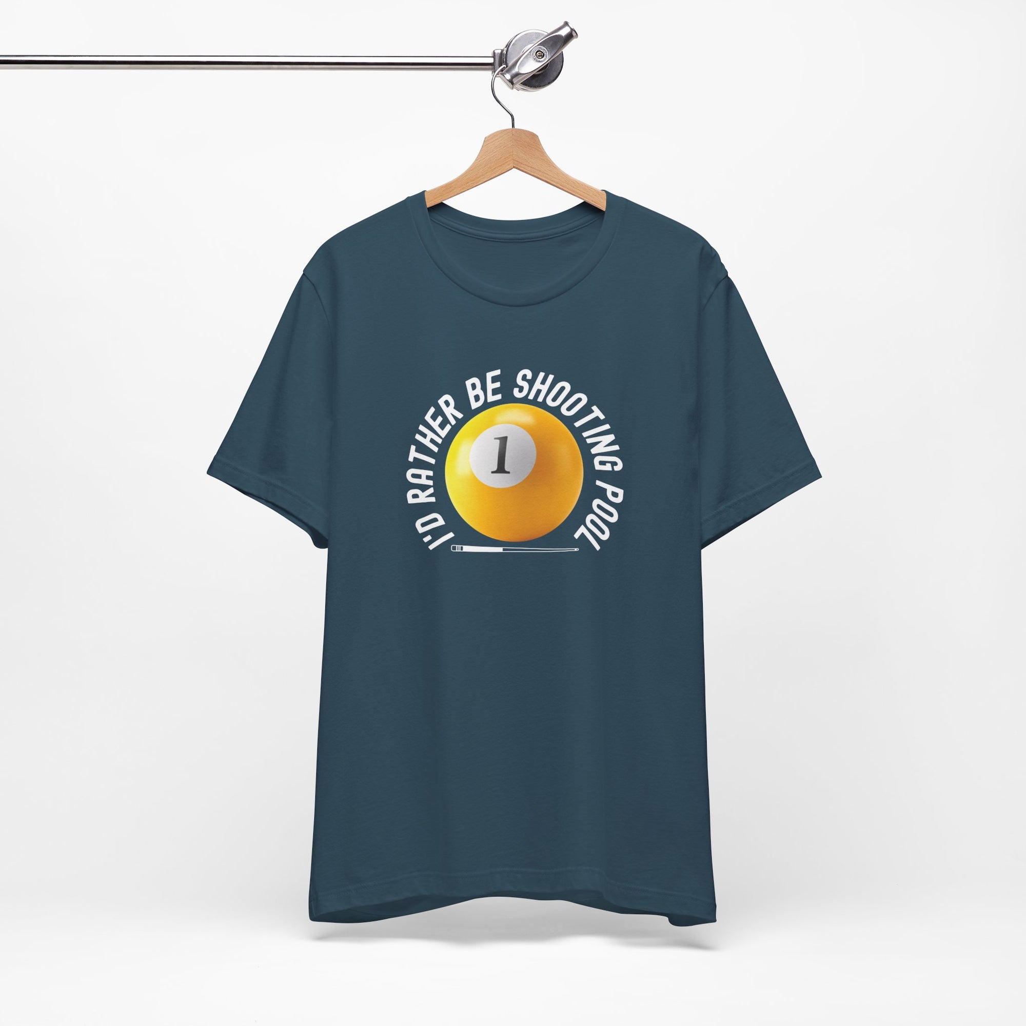 Teal t-shirt with a yellow billiards ball and cue stick graphic and the text "I'd Rather Be Shooting Pool" on a hanger against a white background