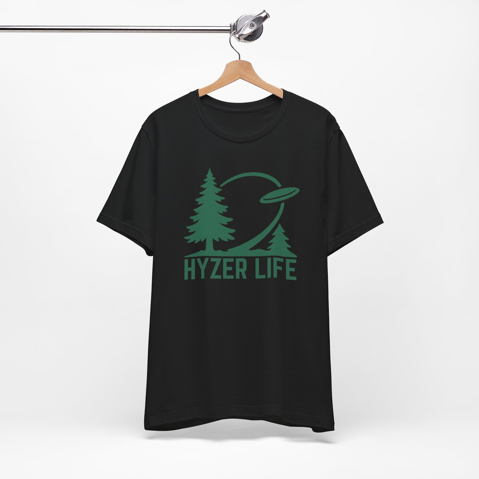 Black t-shirt with green graphic of trees and a disc golf flying with the words 'HYZER LIFE' below the image, on a hanger against a white backgroud