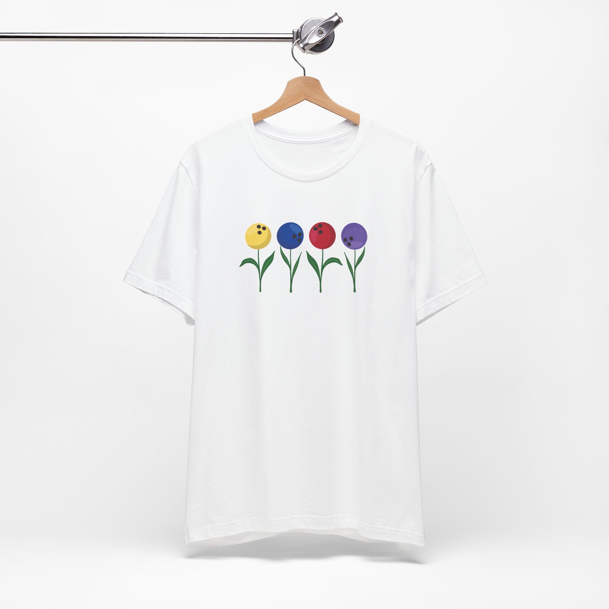 White t-shirt with colorful flowers made out of bowling balls, on a hanger against a white background