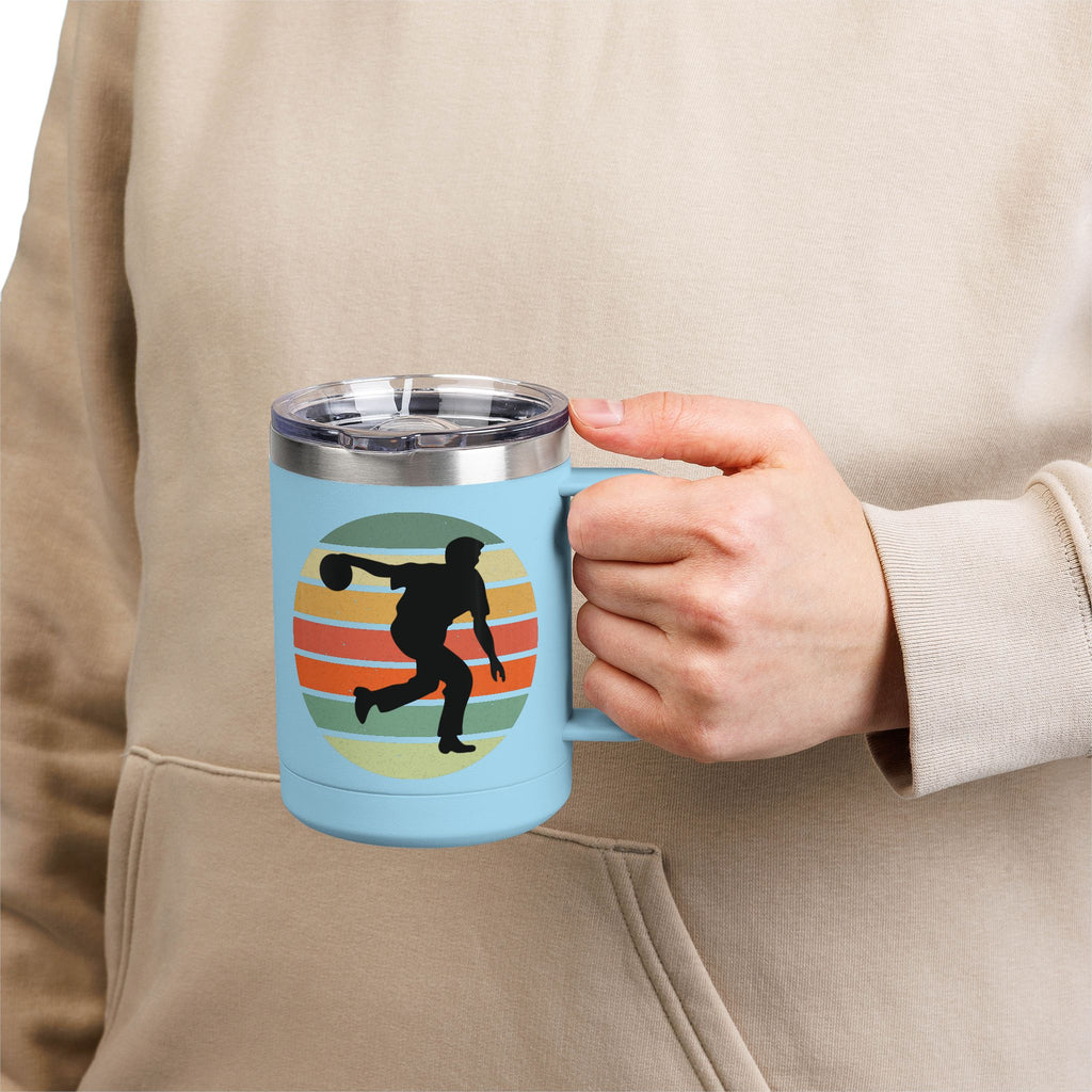 Person holding a teal travel coffee mug with lid and handle with a silhouette of a person bowling and a colorful retro design.