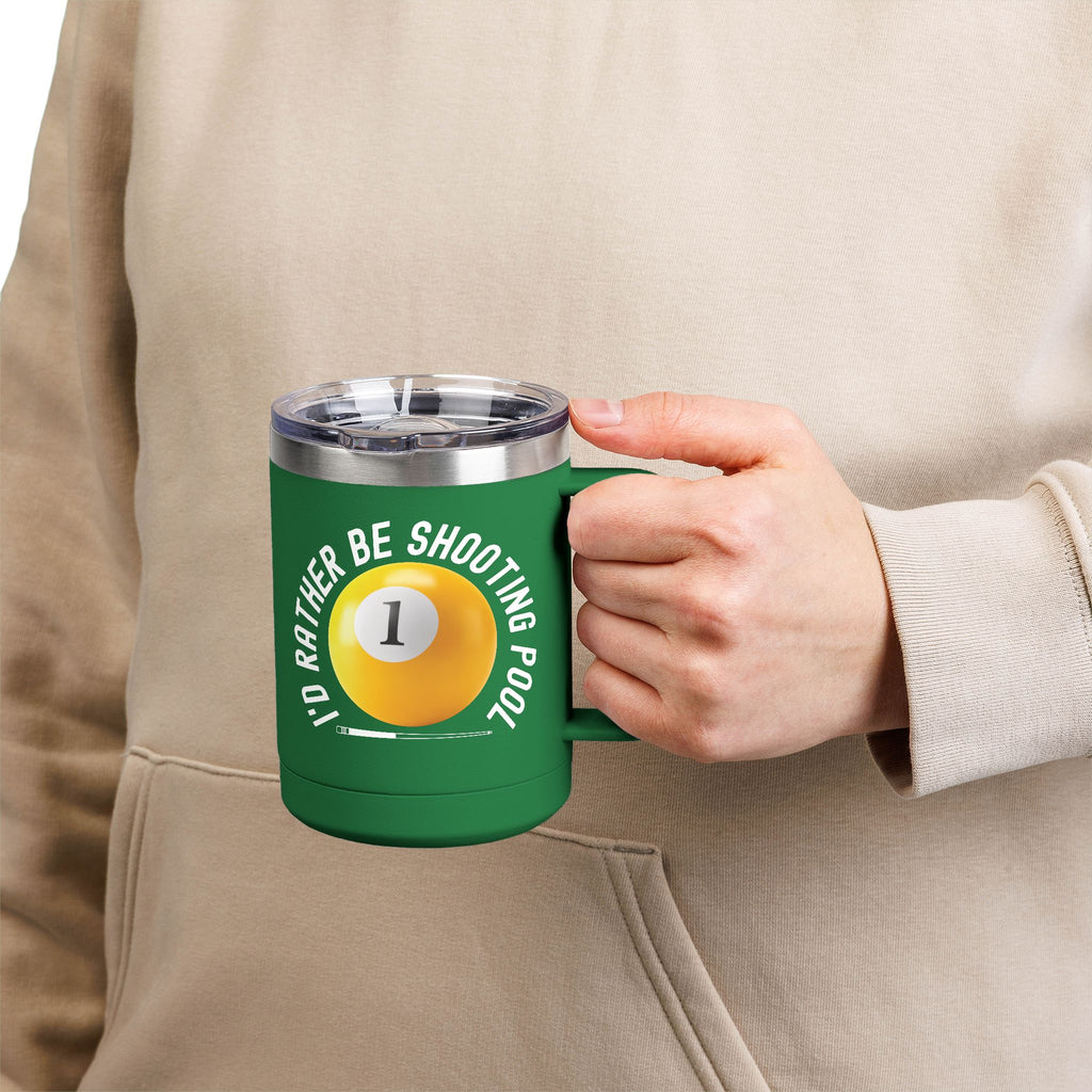 A person holding a green travel coffee mug with lid and handle with a yellow billiards ball and cue stick graphic and the text "I'd Rather Be Shooting Pool" on a white background
