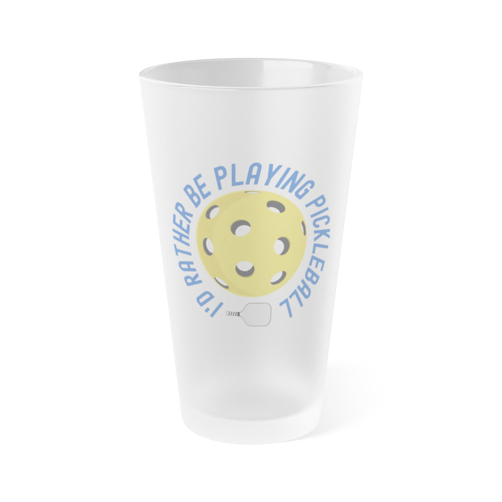 A frosted pint glass with the words "I'd Rather Be Playing Pickleball" surrounding a yellow pickleball and paddle, on a white background