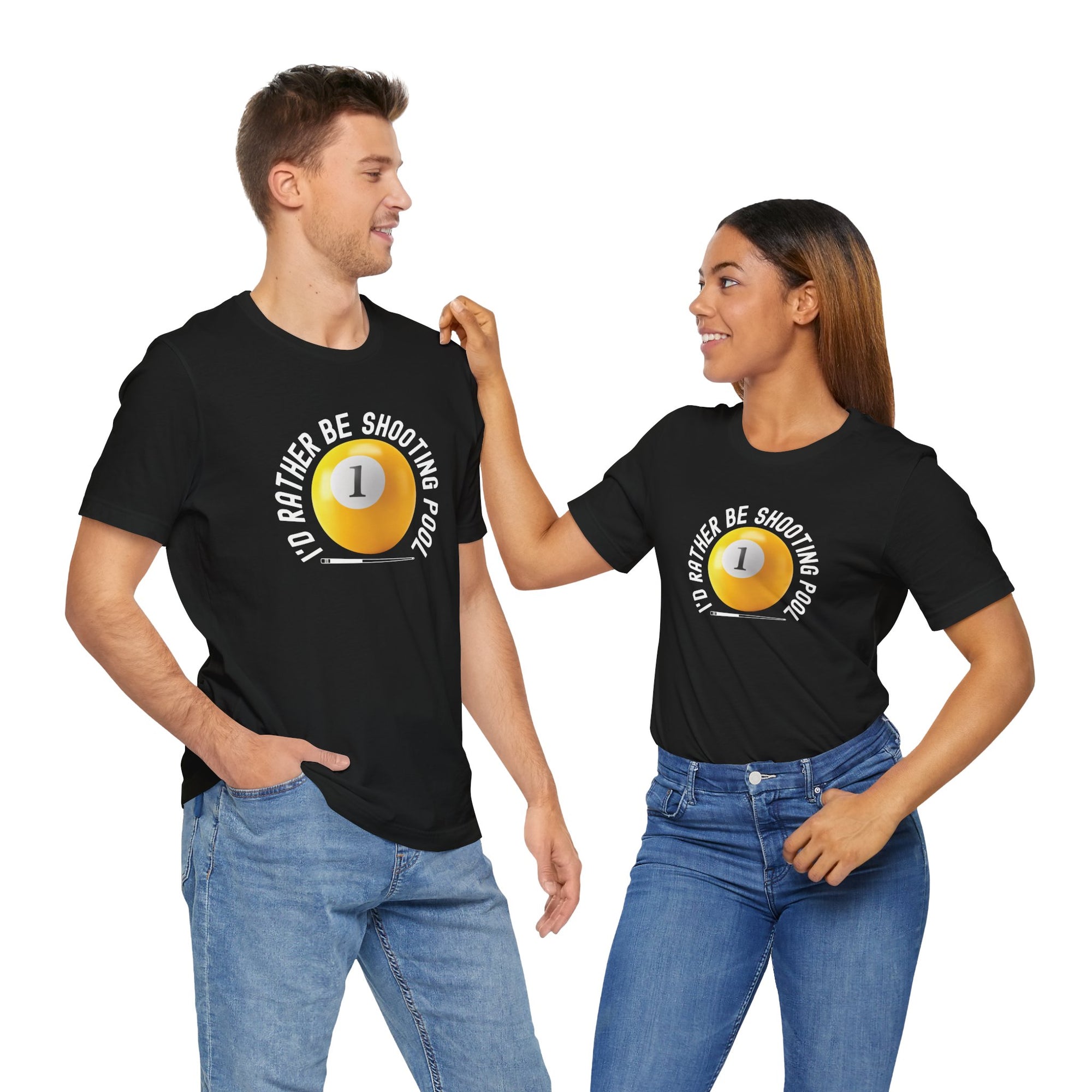 A man and a women both wearing a black t-shirt with a yellow billiards ball and cue stick graphic and the text "I'd Rather Be Shooting Pool" on a hanger against a white background.