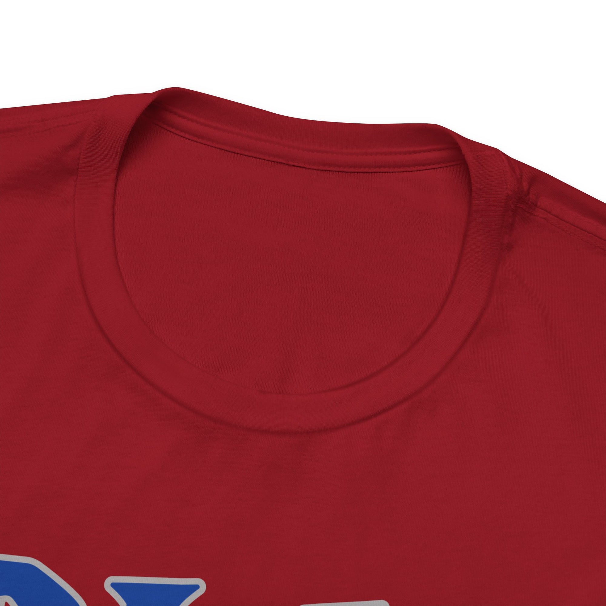 The neckline view of a red t-shirt with 'DINK IT!' text in blue and outlined in gray, on a hanger against a white background