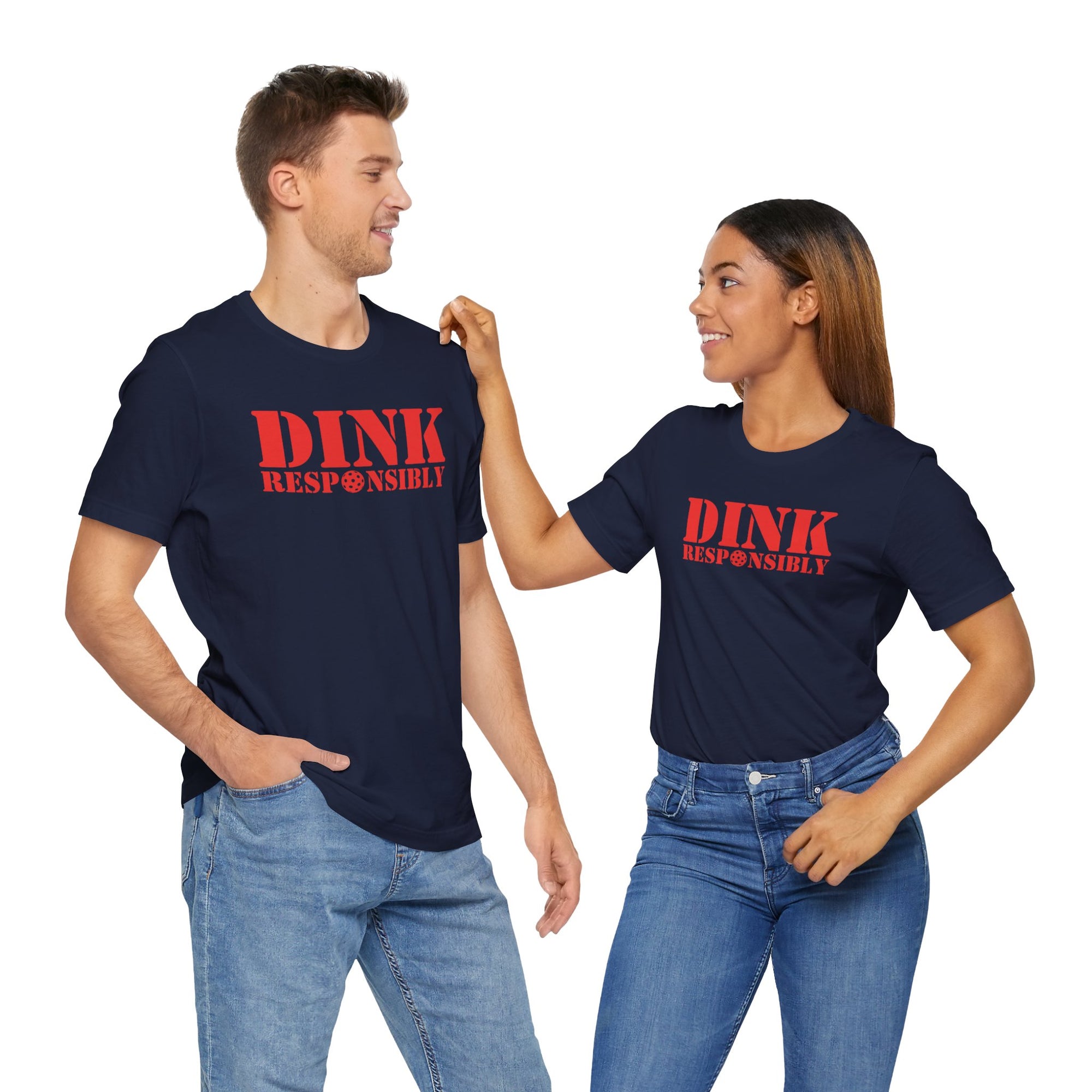 A man and a woman both wearing a navy blue t-shirt with red text 'DINK RESPONSIBLY' with a pickleball replacing the "O" in "Responsibly" against a white background