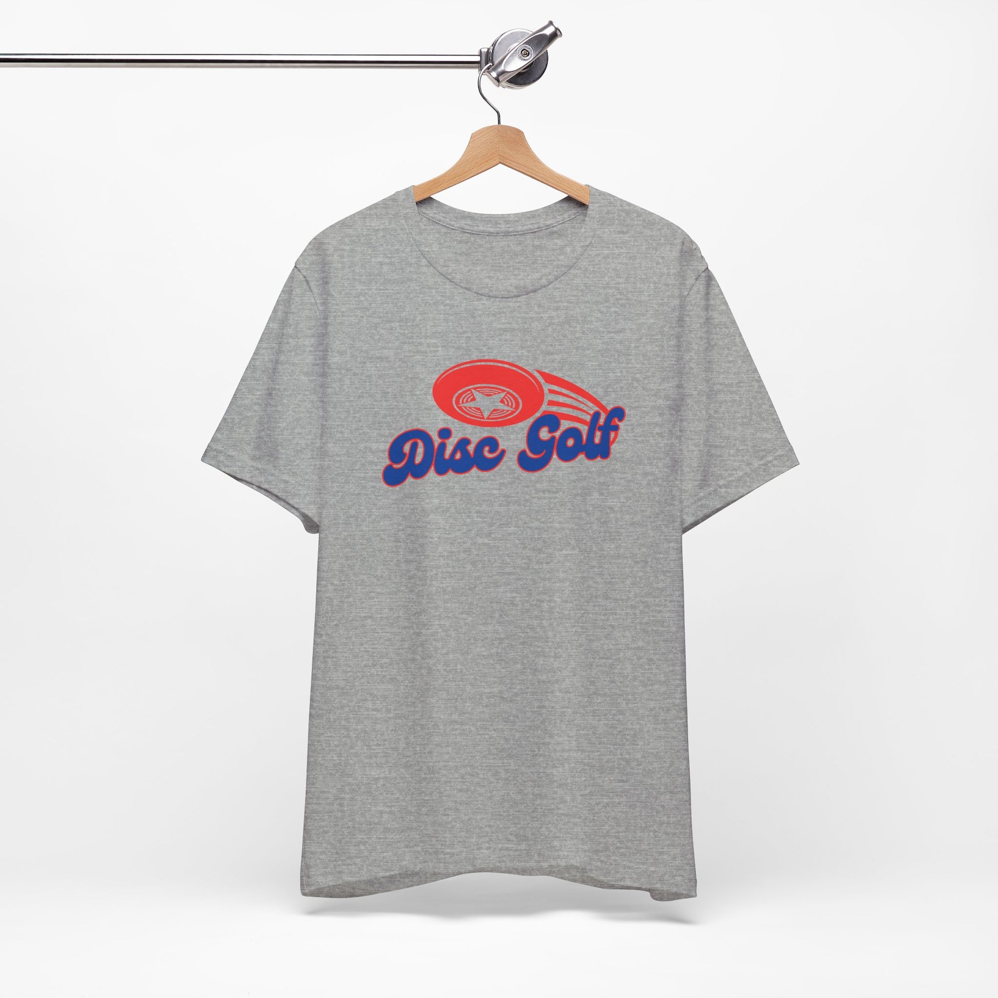 Light gray t-shirt with 'Disc Golf' in a blue script text outlined in red and disc golf with motion trails, on a hanger against a white background