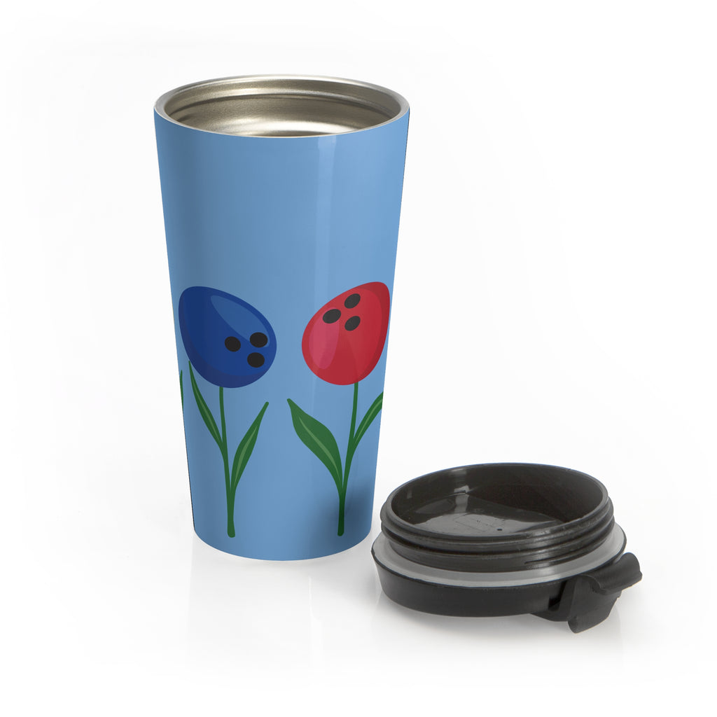 Light blue travel mug with a black lid next to the mug, with colorful flowers made out of bowling balls, on a white background