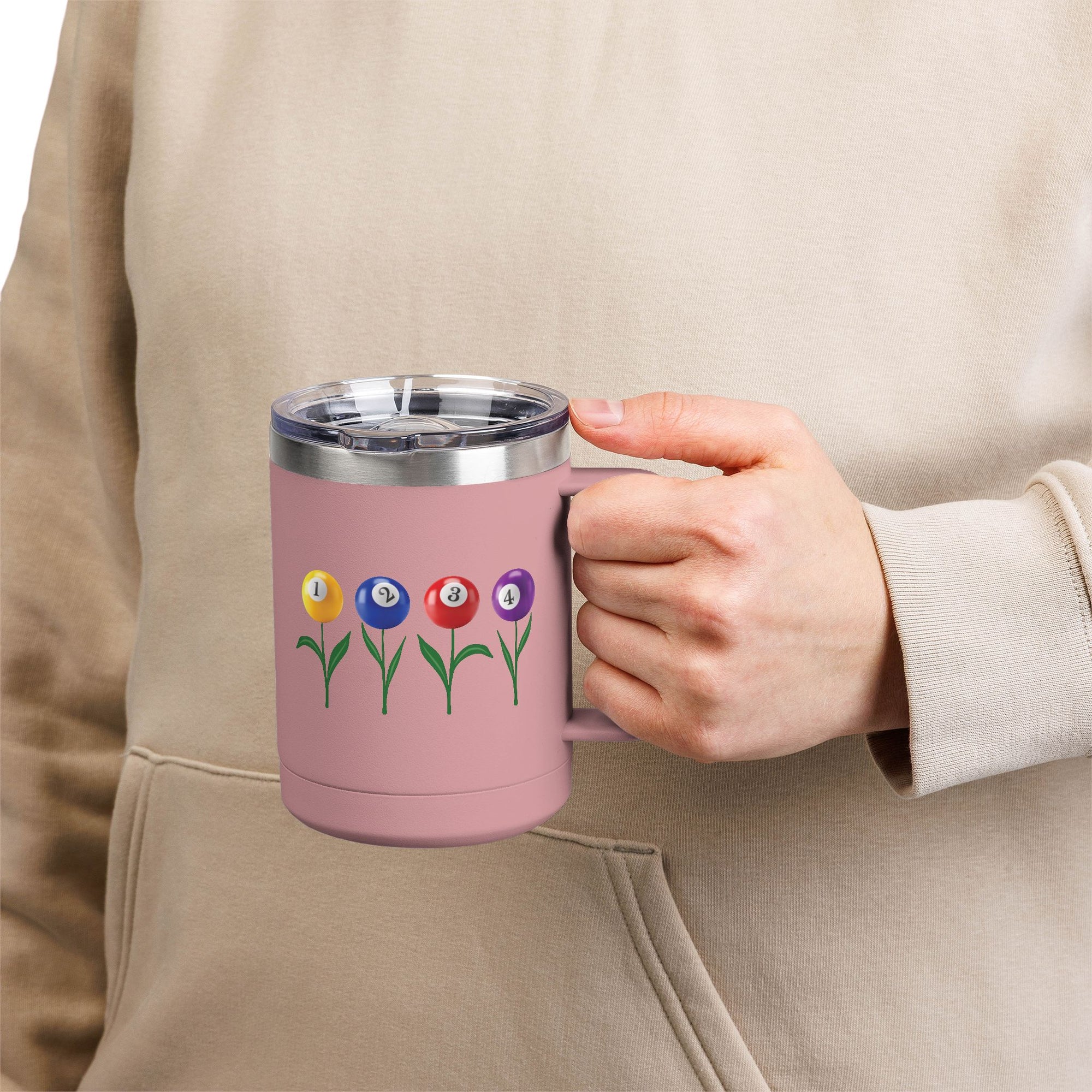 A person holding a pink travel coffee tumbler mug with handle and lid, with four colorful flowers made out of billiards balls with green stems