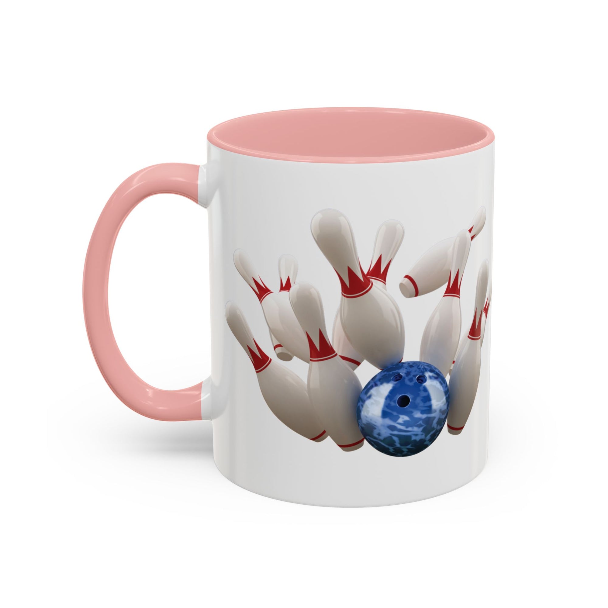 A white ceramic coffee mug with pink accents on the handle and interior, with a graphic of a blue bowling ball knocking over bowling pins, on a white background