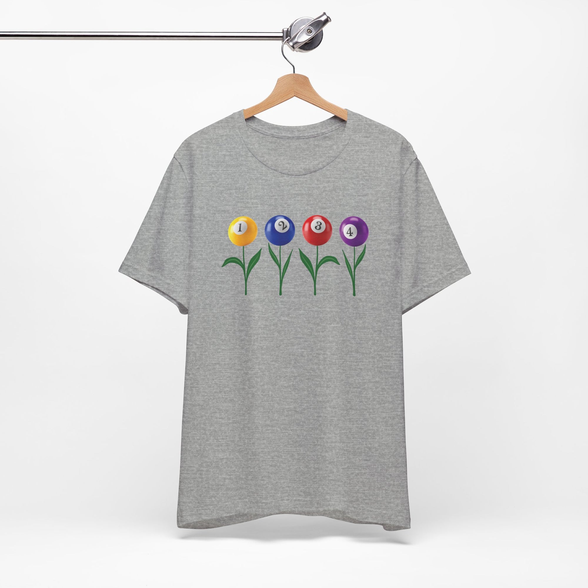Gray t-shirt with four colorful flowers made out of billiards balls with green stems, on a hanger against a white background