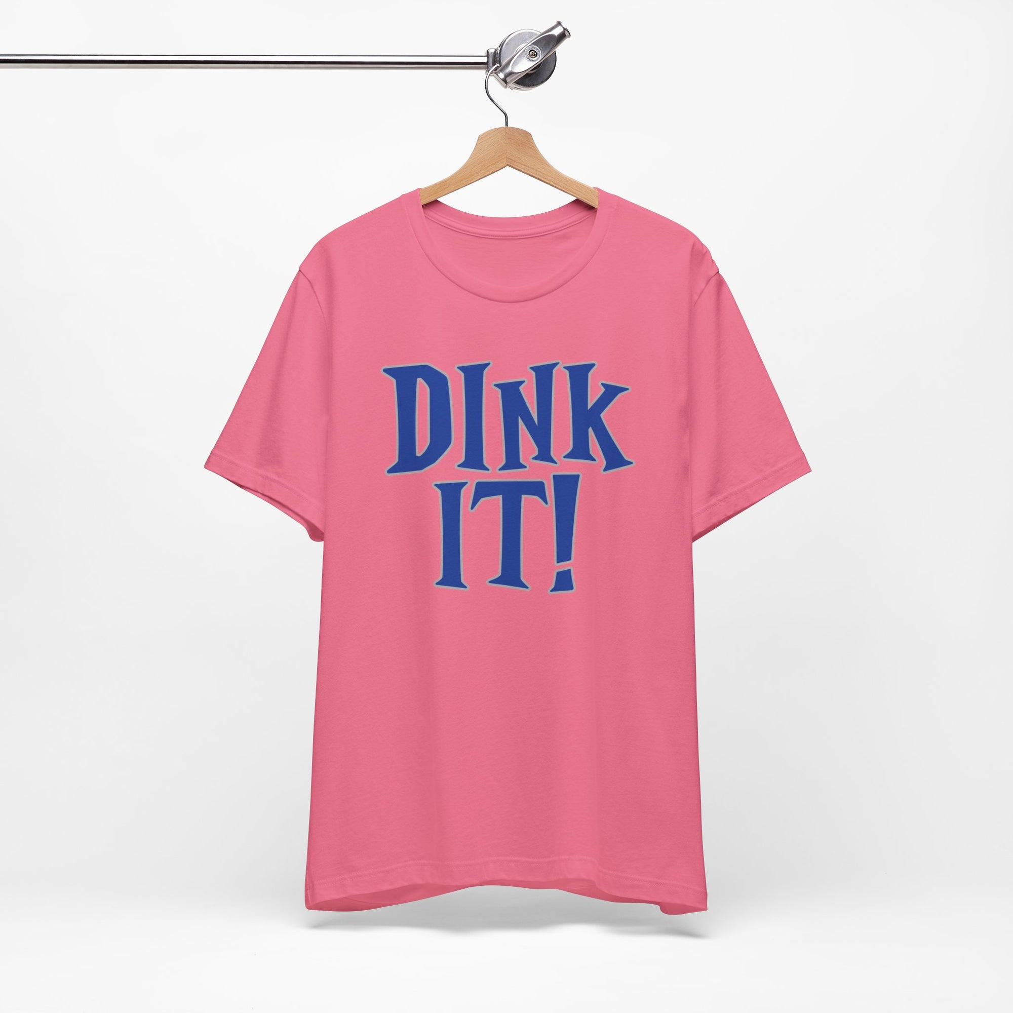 Pink t-shirt with 'DINK IT!' text in blue and outlined in gray, on a hanger against a white background