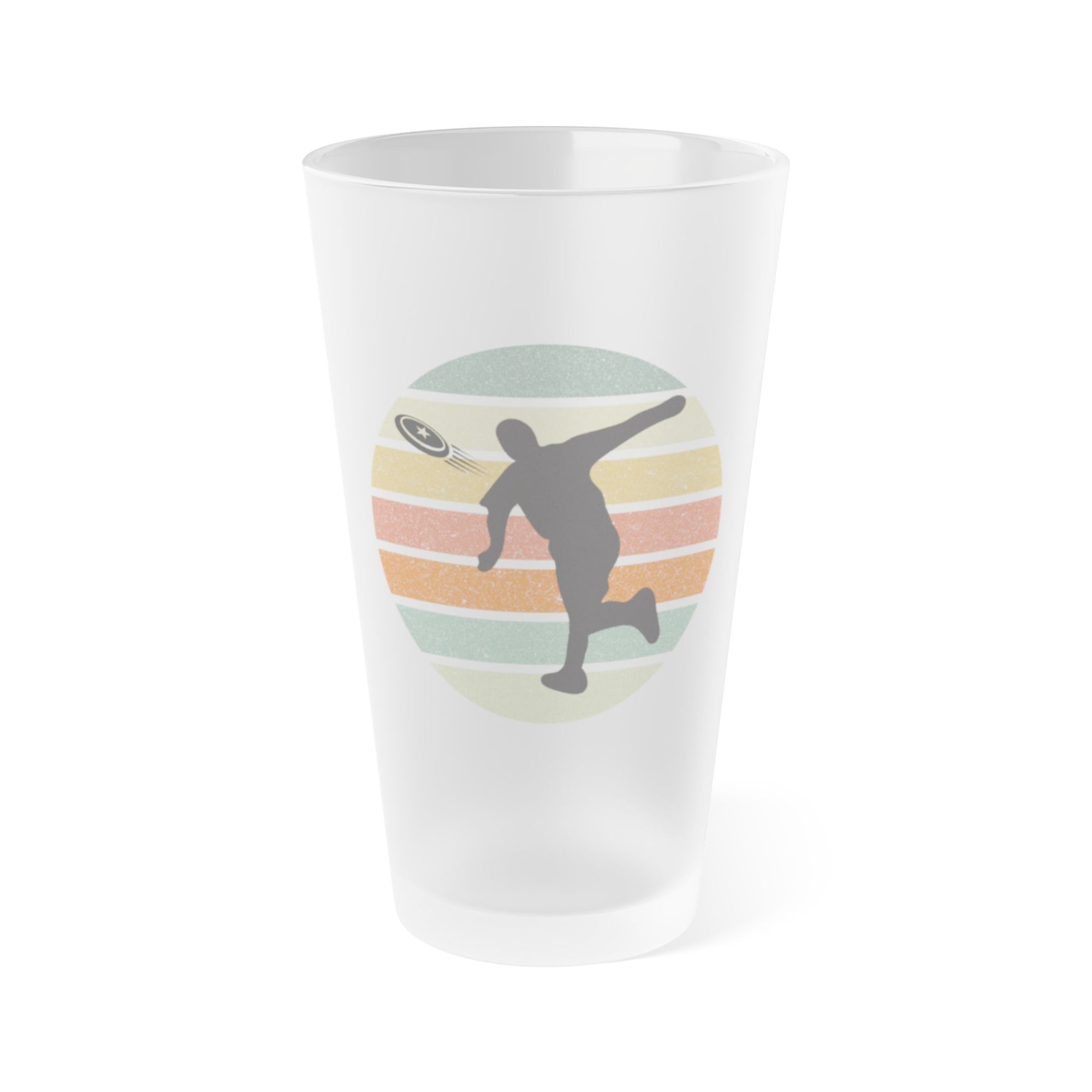 A frosted pint glass featuring a disc golf player silhouette in black in front of a circle of colorful lines, on a white background