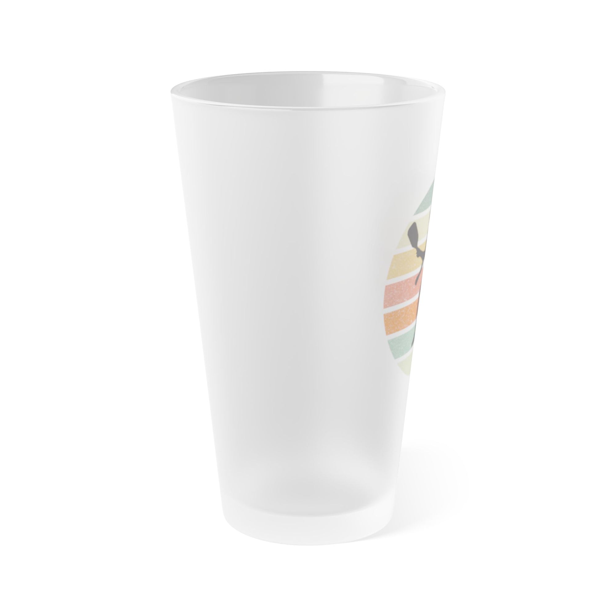 Side view of a frosted pint glass with a silhouette of a pickleball player over a circle of colorful lines, on a white background