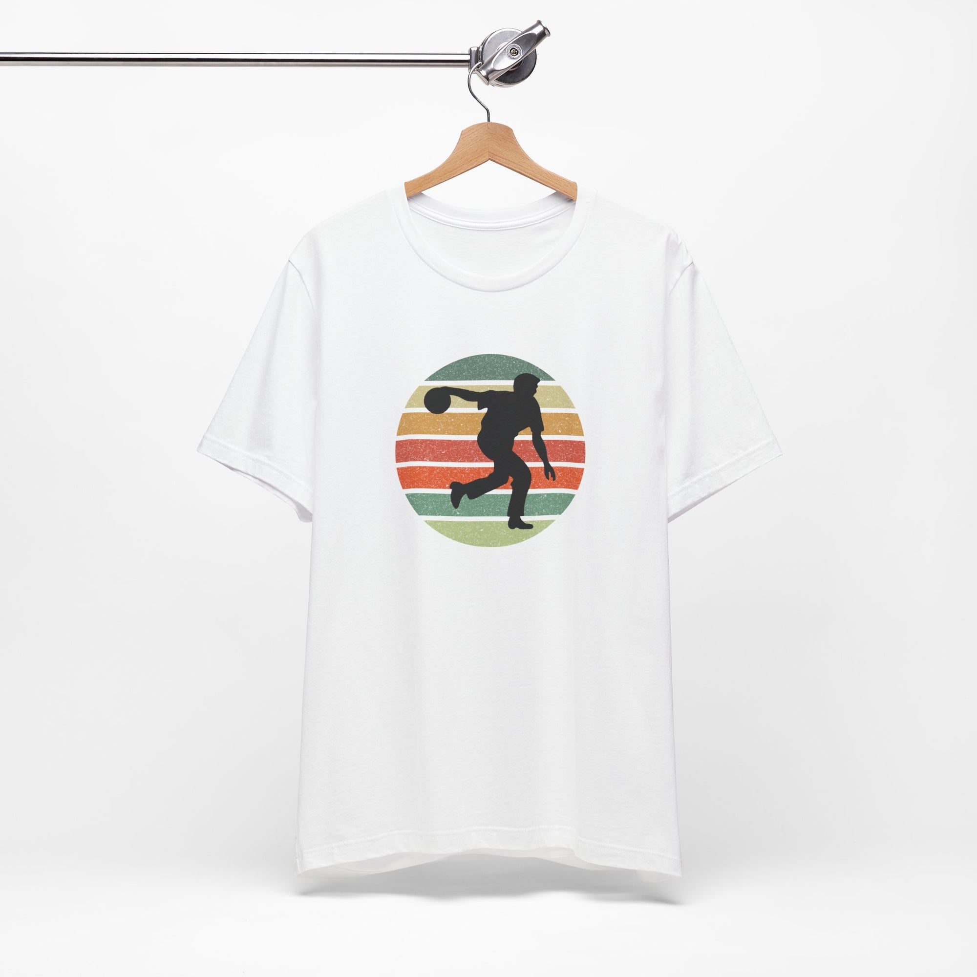 White t-shirt with a graphic of a silhouette of a bowler over a colorful retro image, hanging on a wooden hanger against a white background.