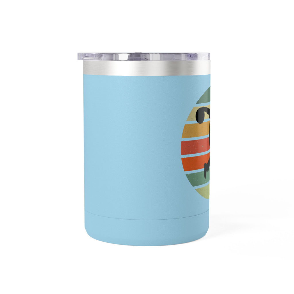 Side view of a teal travel coffee mug with lid and handle with a silhouette of a person bowling and a colorful retro design on a white background.