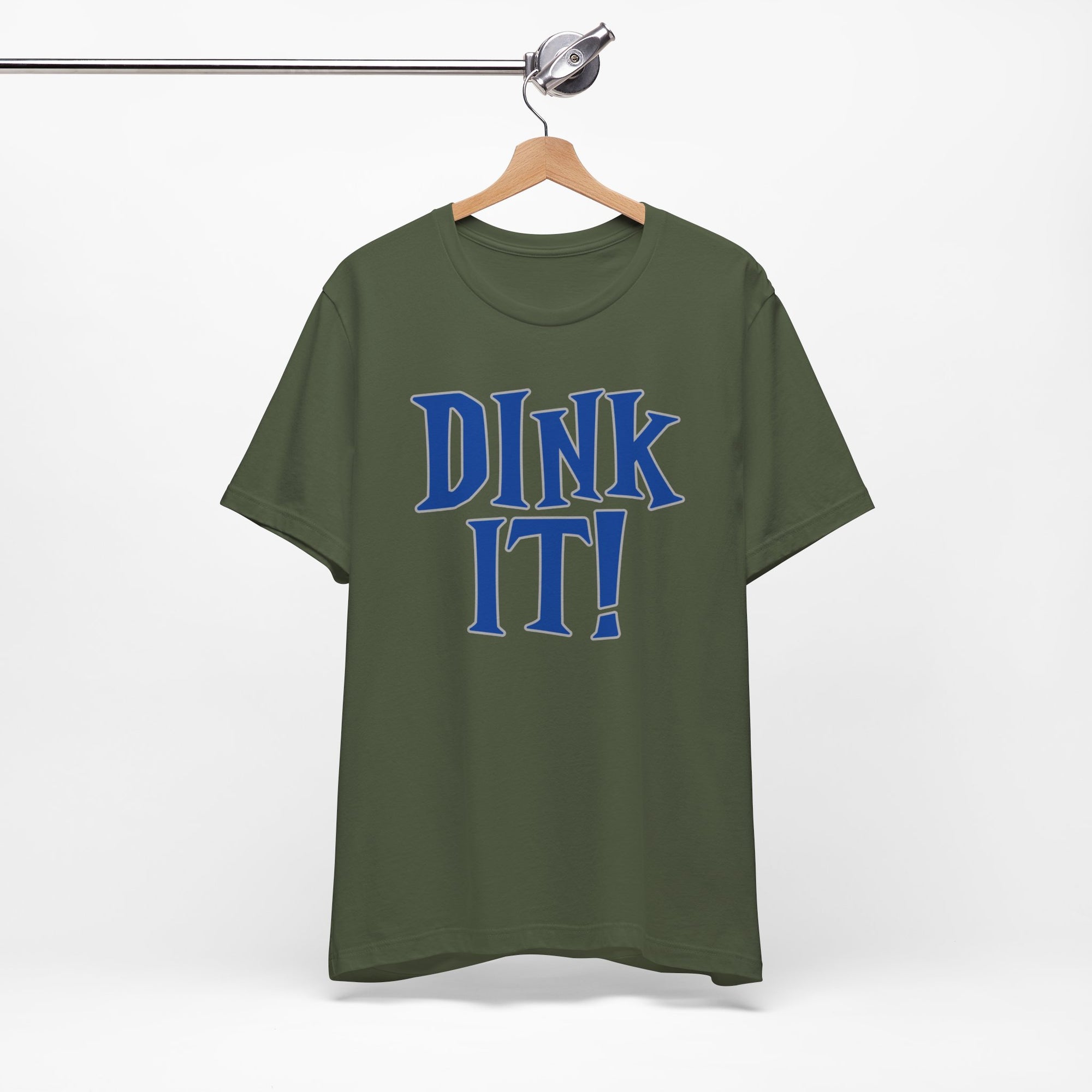 Military green t-shirt with 'DINK IT!' text in blue and outlined in gray, on a hanger against a white background